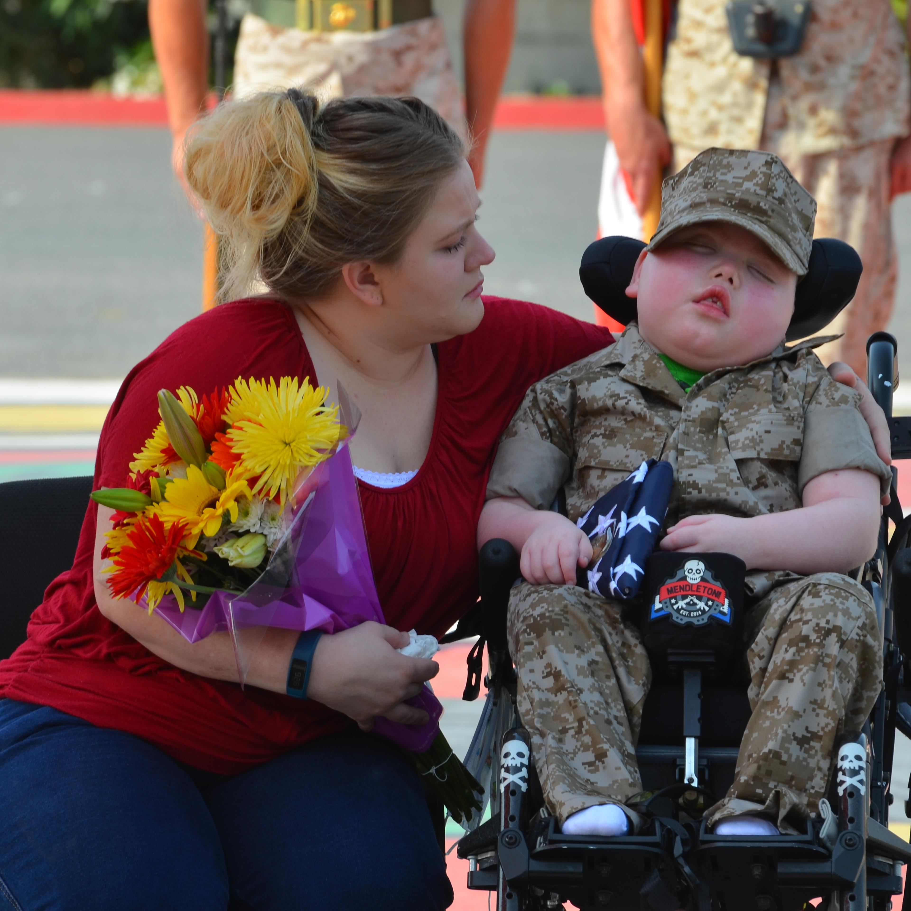 Wyatt Gillette is named an honorary Marine while his mother, Felishia Gillette, sits beside him at a ceremony at the Marine Corps Base Camp in Pendleton, Calif., on July 30.