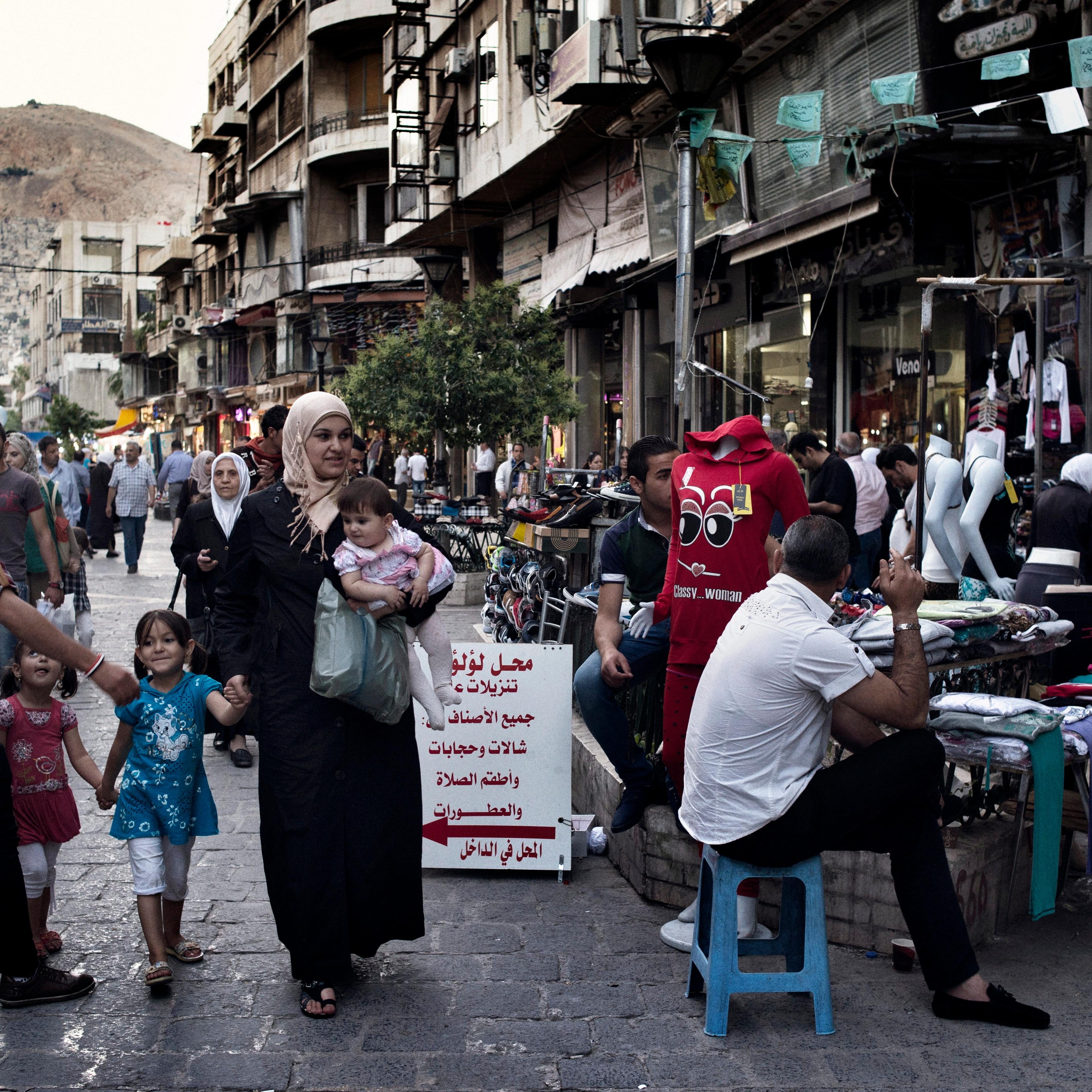 A family walks down a street in Damascus on May 14, 2014.