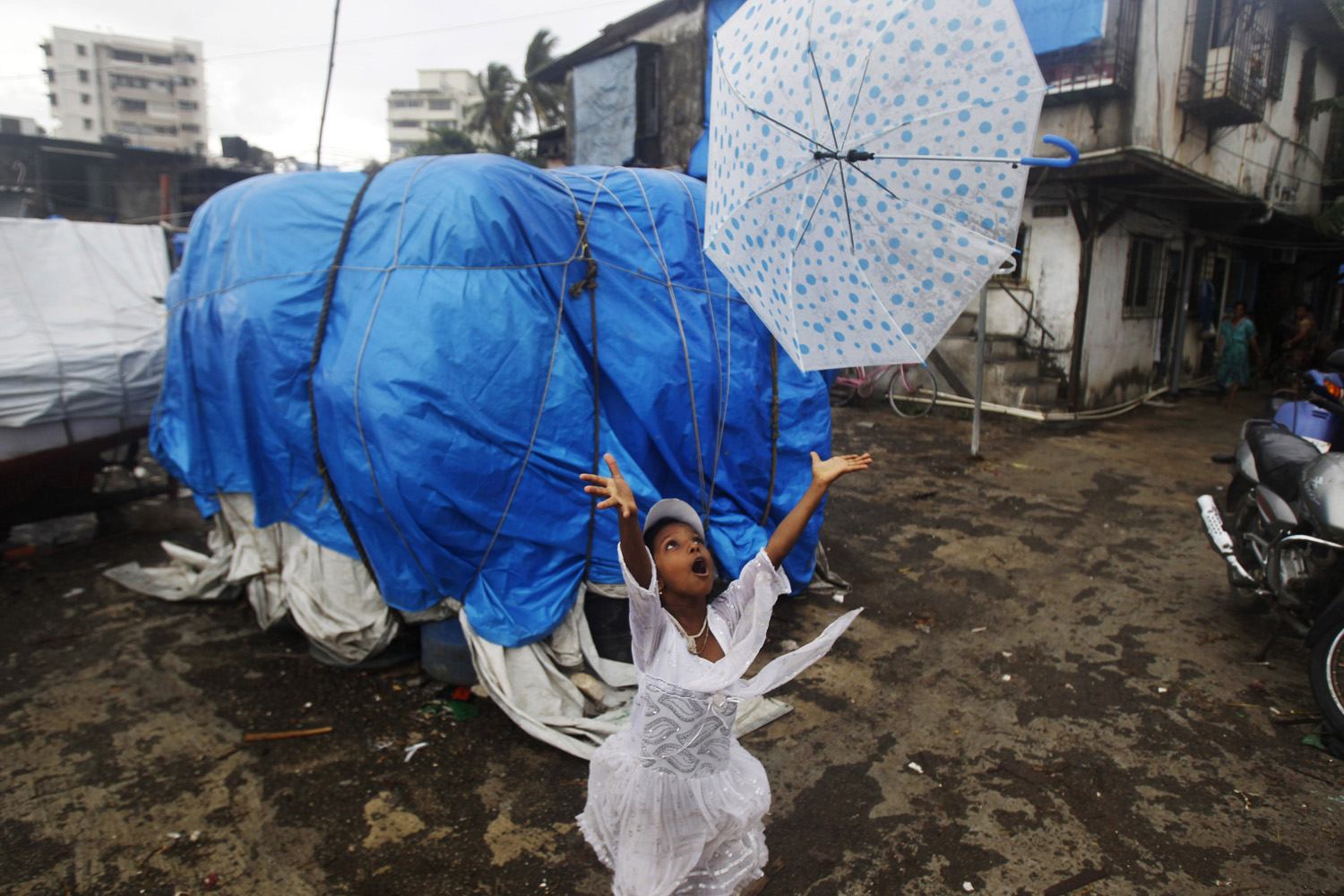 June 17, 2012. A girl tries to recover her umbrella blowing away in the wind in Mumbai. 
