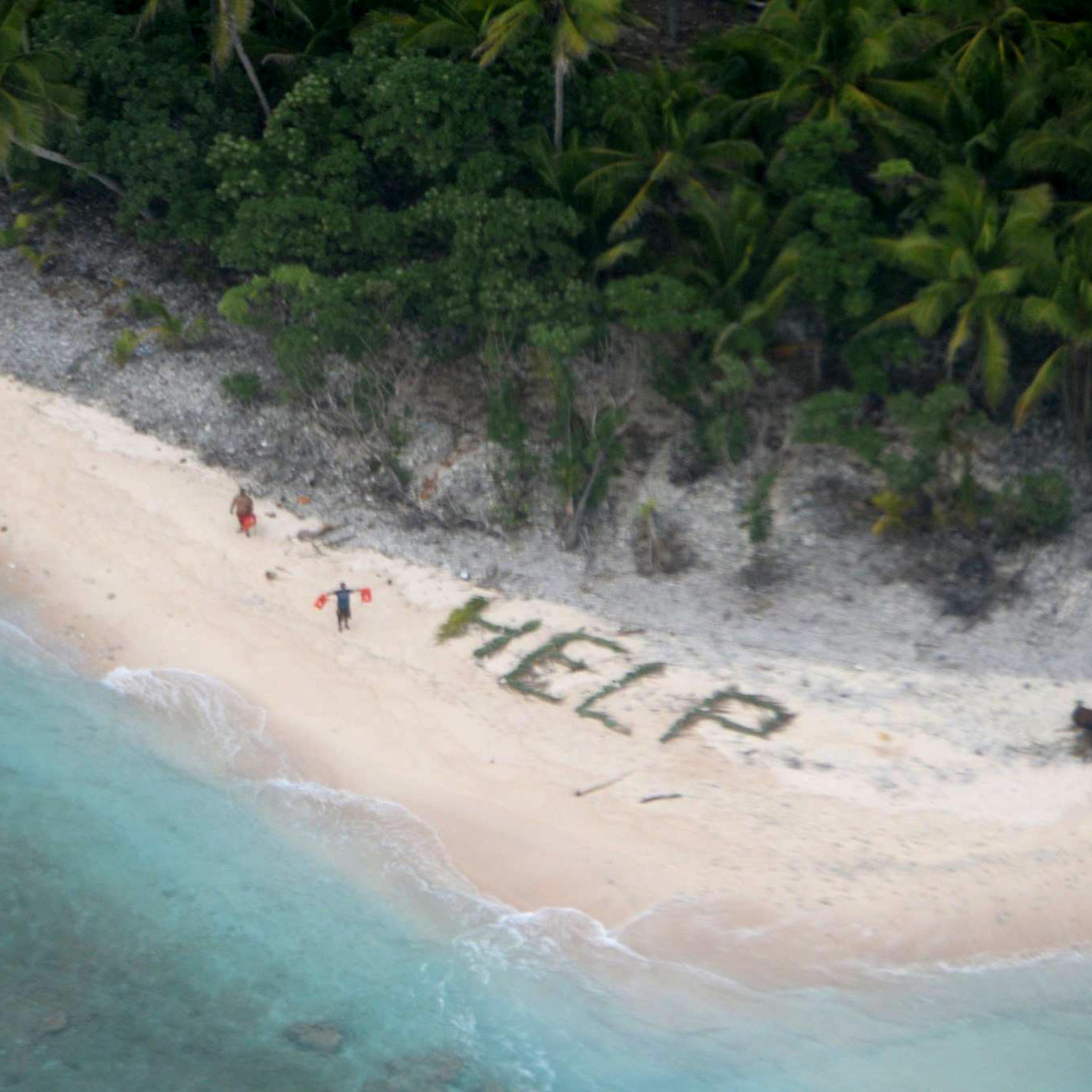 Two of three men stranded on the uninhabited island of Fanadik in Micronesia wave life jackets as a U.S. Navy P-8A Poseidon maritime patrol and reconnaissance aircraft discovers them