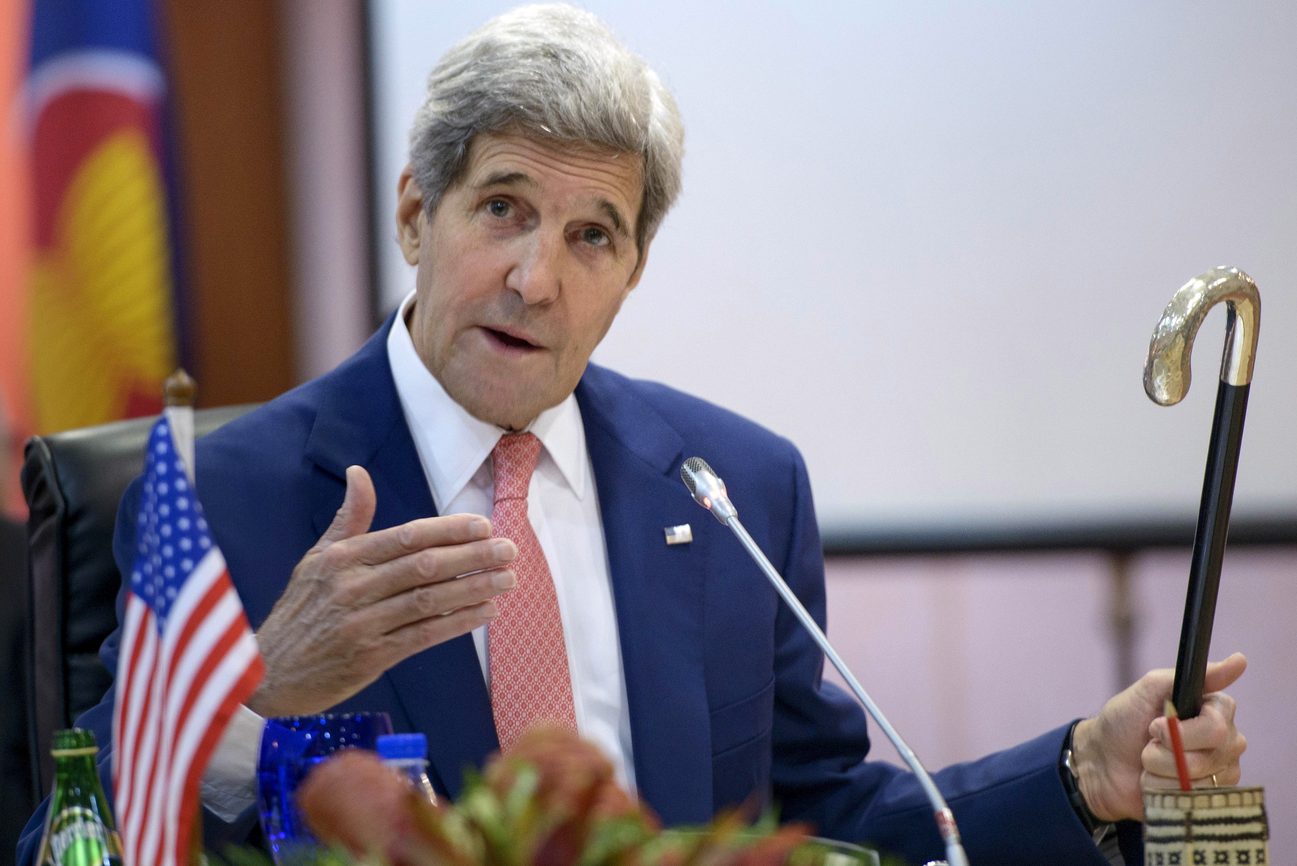 US Secretary of State John Kerry holds up Joseph Kennedy's cane, which has been used by John F. Kennedy and Ted Kennedy, while talking about his broken leg during the 8th Lower Mekong Initiative Ministerial Meeting at the Putra World Trade Center