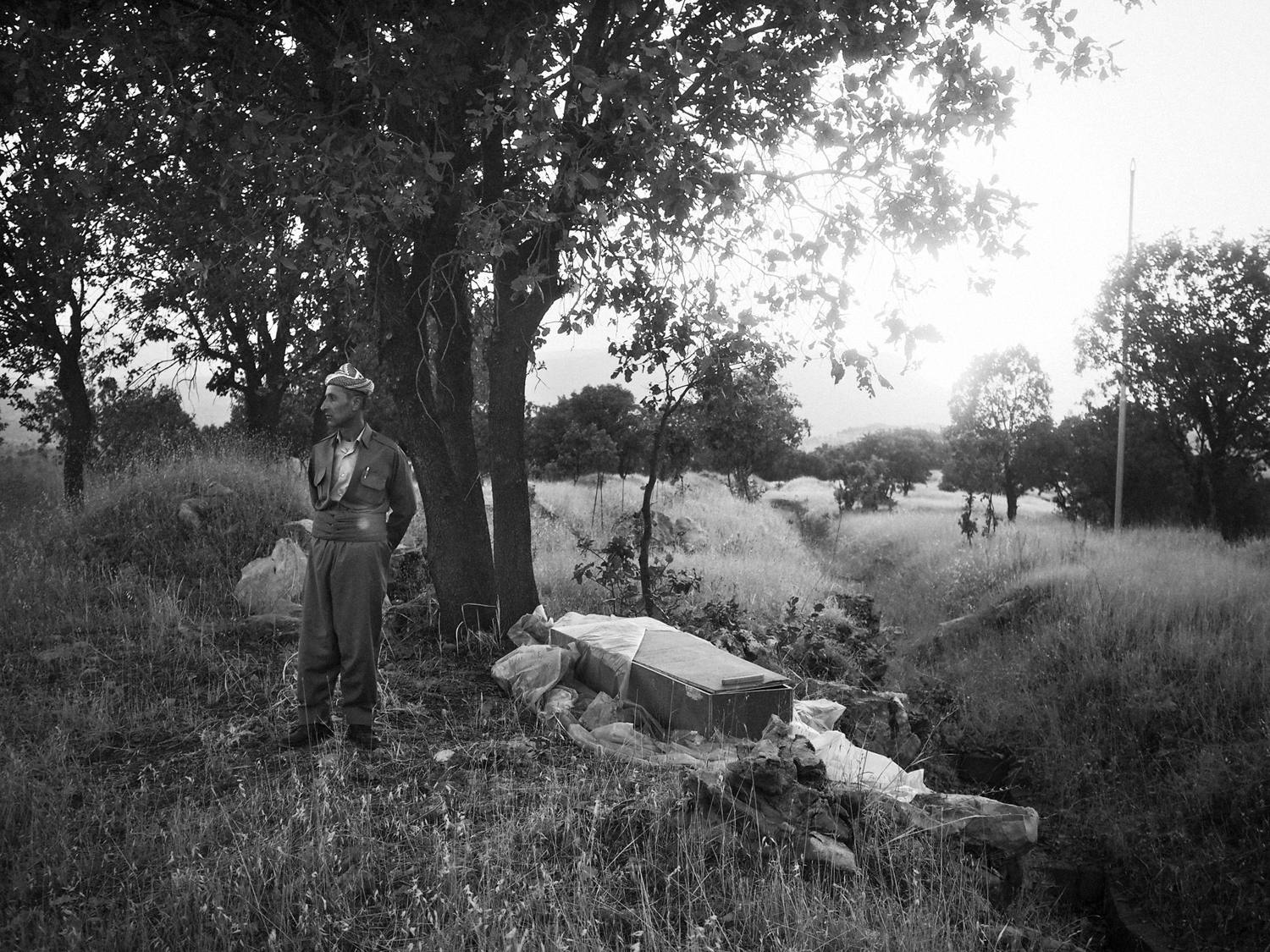 Barzan, Iraq. July 14, 2014.A Kurdish man stands next to an empty coffin that once contained the remains of a villager from Barzan, the hometown of President Masoud Barzani. In the late 1980's, Saddam Hussein's forces targeted Barzan, launching several a