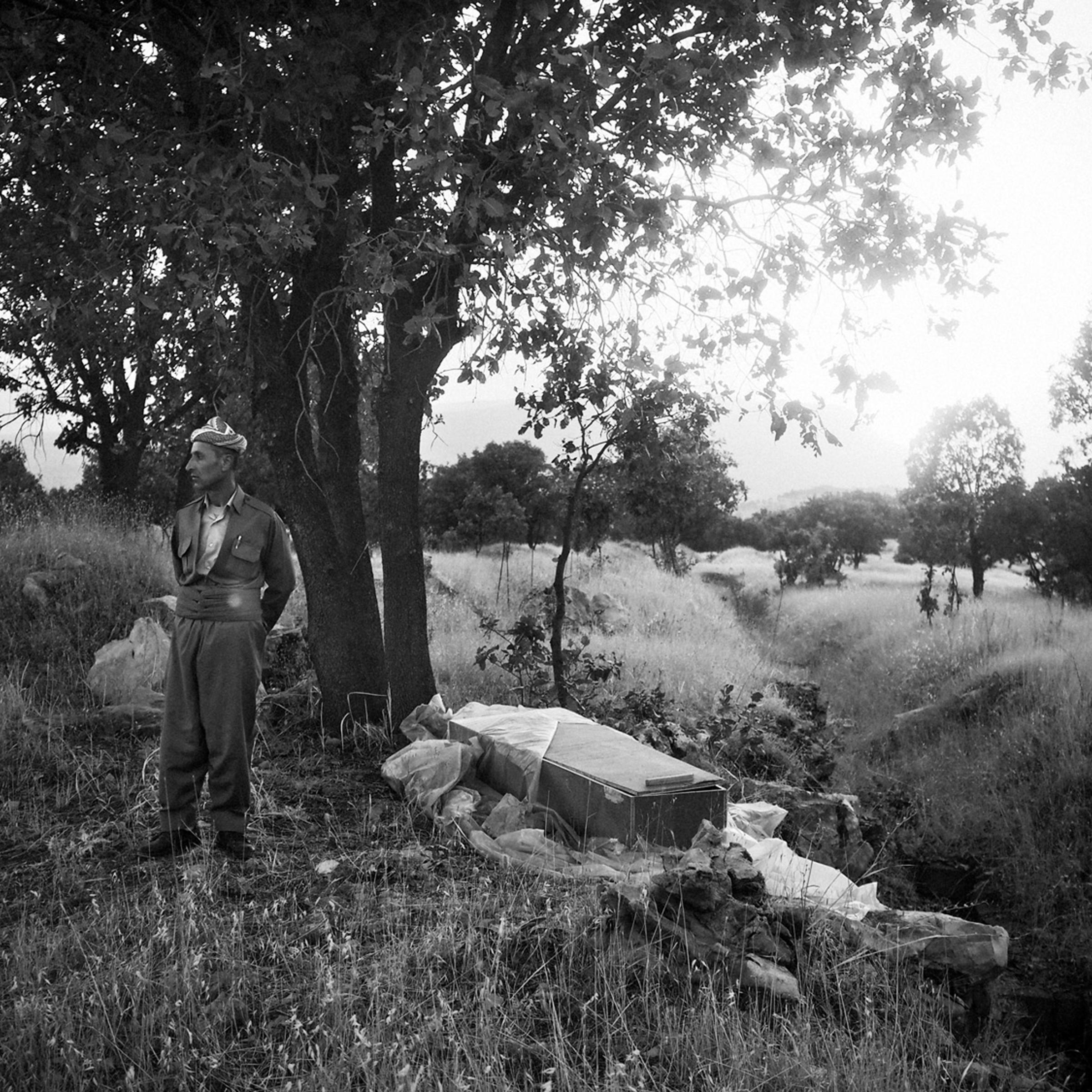 Barzan, Iraq. July 14, 2014.A Kurdish man stands next to an empty coffin that once contained the remains of a villager from Barzan, the hometown of President Masoud Barzani. In the late 1980's, Saddam Hussein's forces targeted Barzan, launching several a