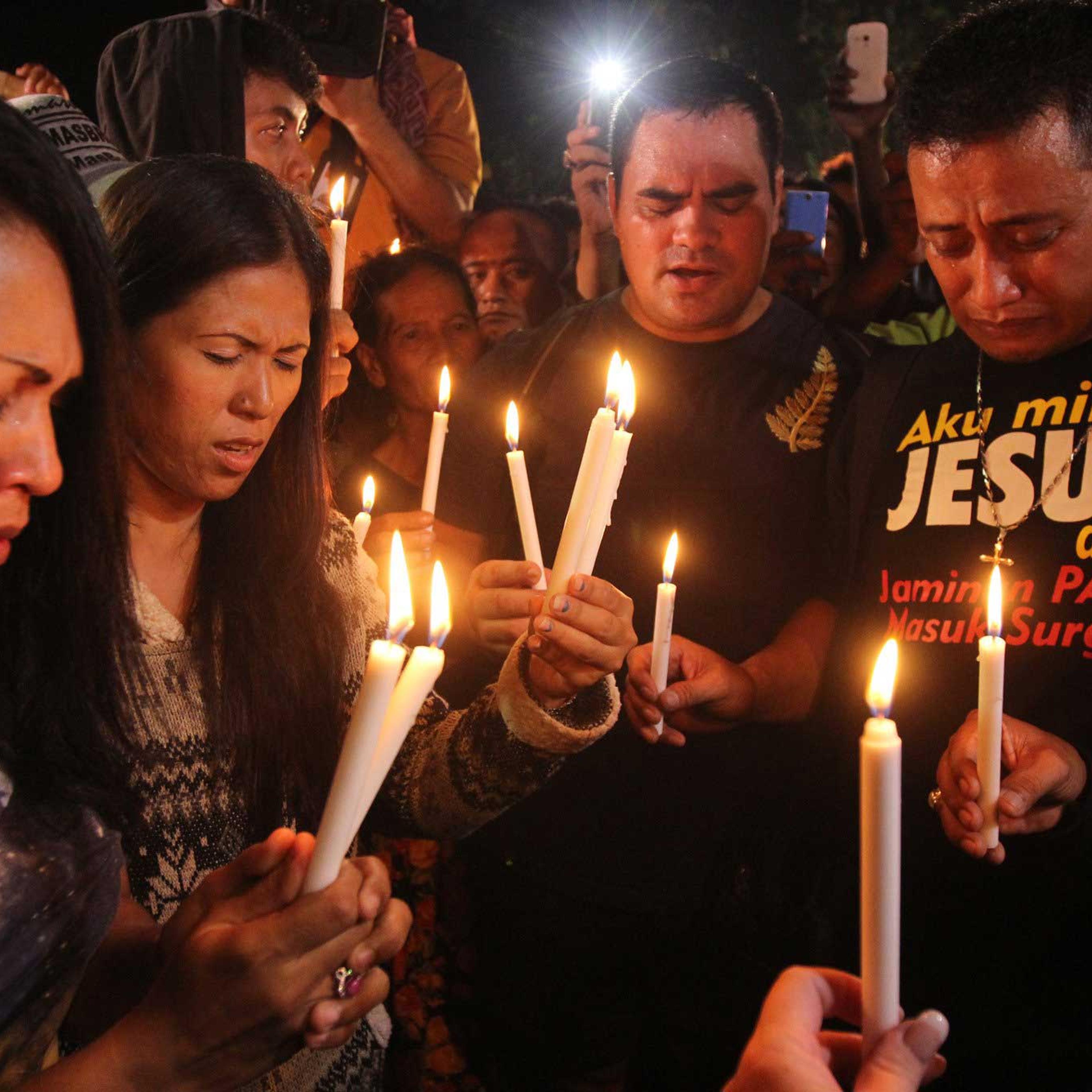 People hold candles to pray for death-row prisoners at Wijayapura port in Cilacap, Indonesia on April 29, 2015.