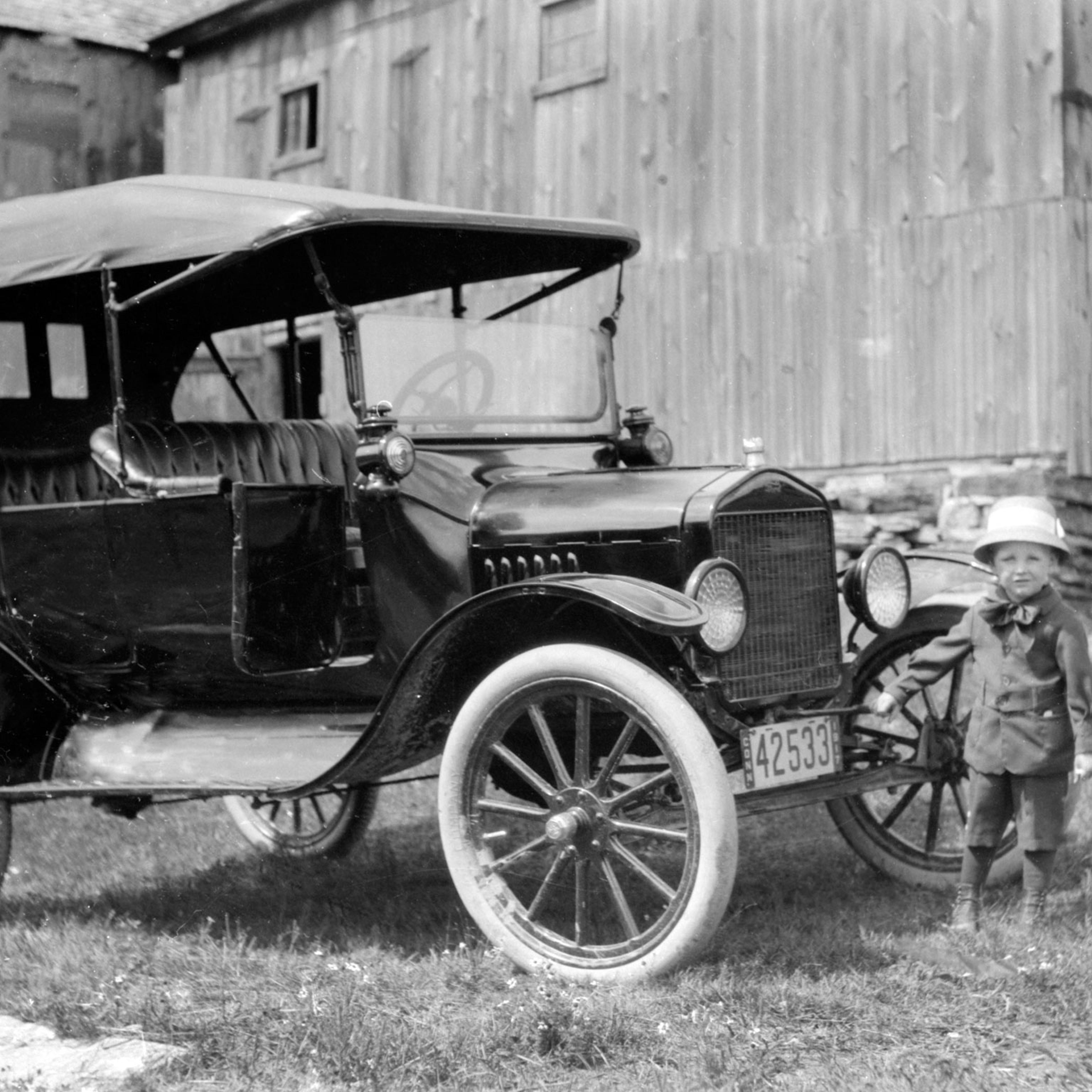 Young boy with the family Model T, on the farm, 1917.