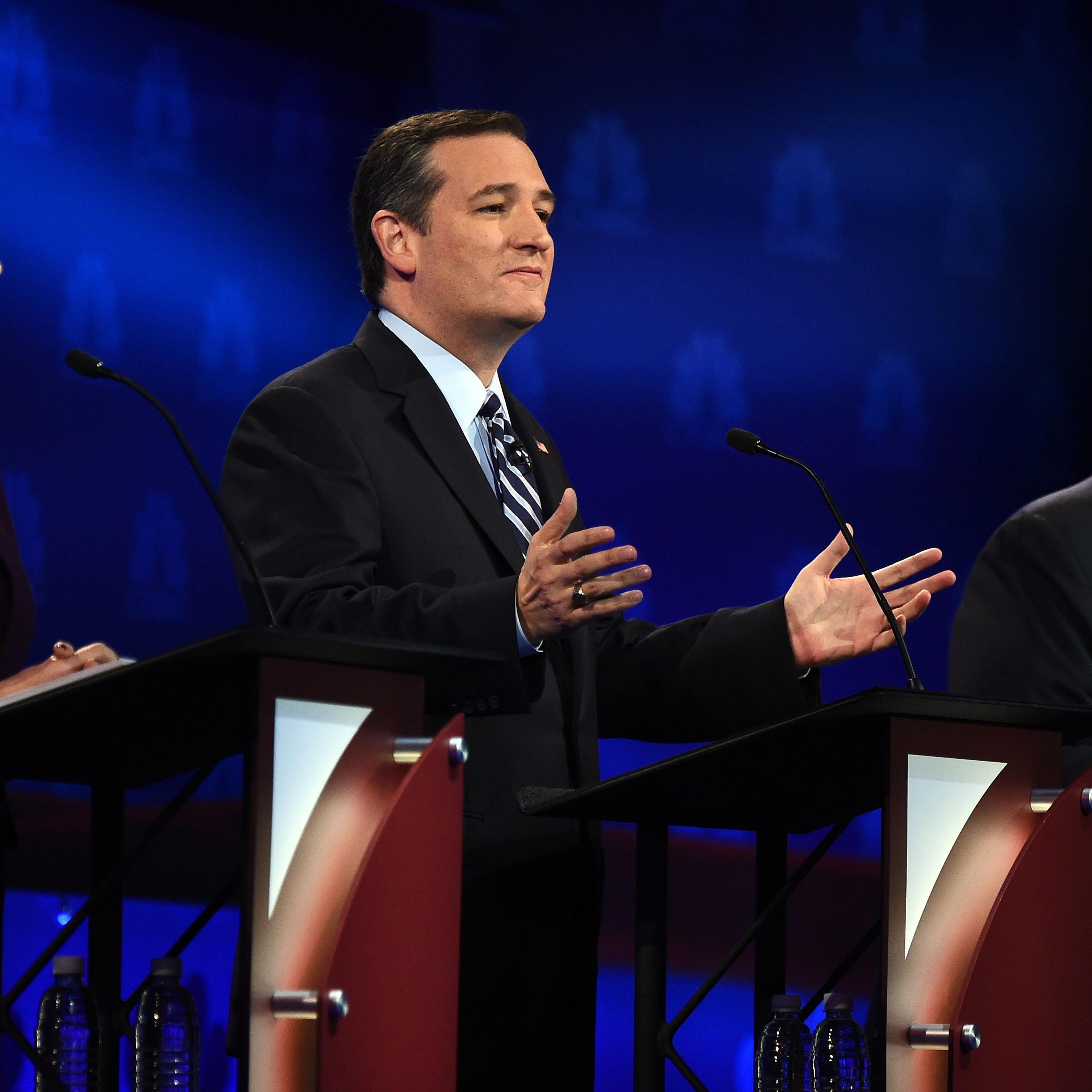 Republican Presidential hopeful Ted Cruz (C) gestures as Carly Fiorina (L) and Chris Christie look on during the CNBC Republican Presidential Debate, October 28, 2015 at the Coors Event Center at the University of Colorado in Boulder, Colo.