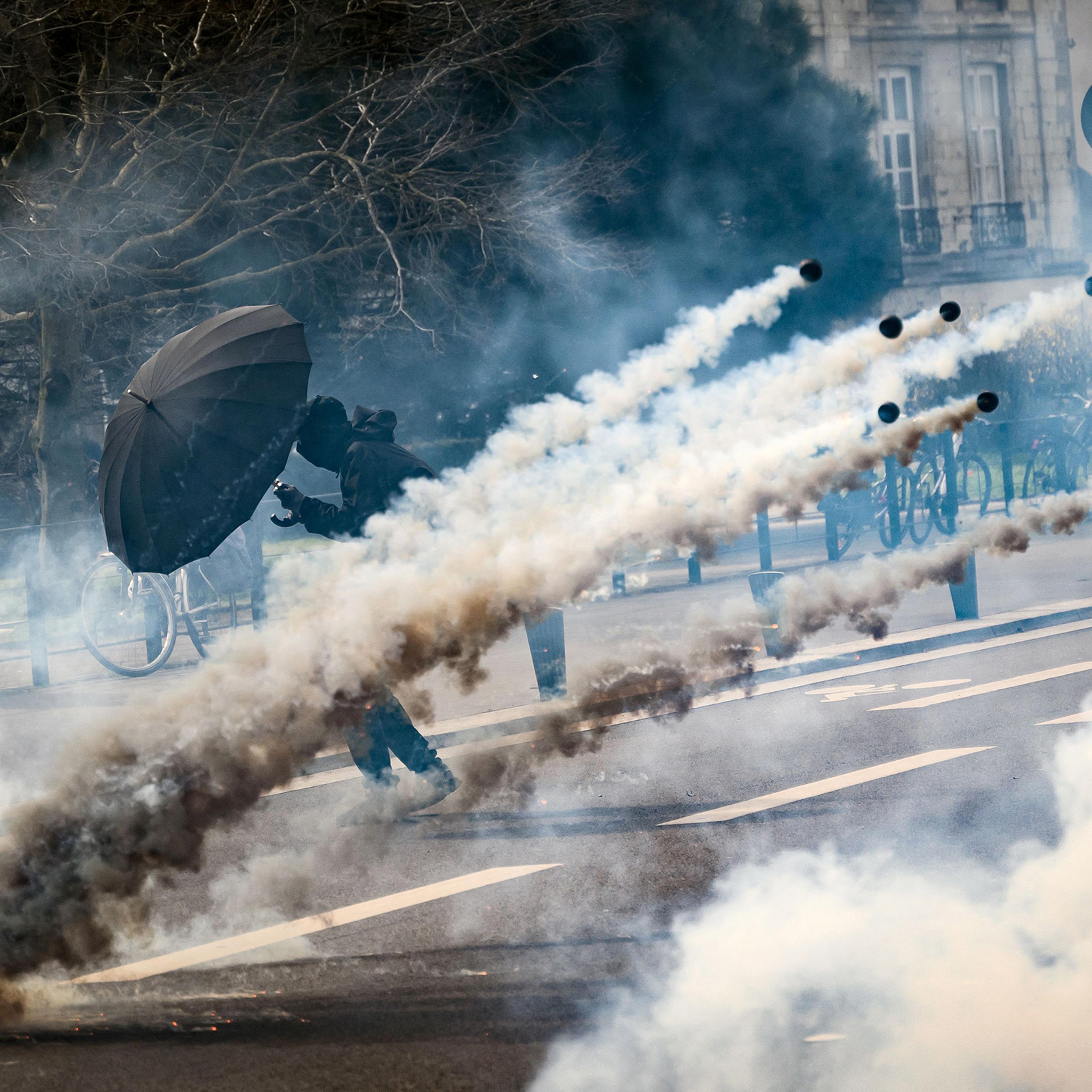 A protestor holds an umbrella to protect from teargas during a demonstration on the 8th day of strikes and protests across the country against the government's proposed pensions overhaul, in Nantes, France, on March 15.