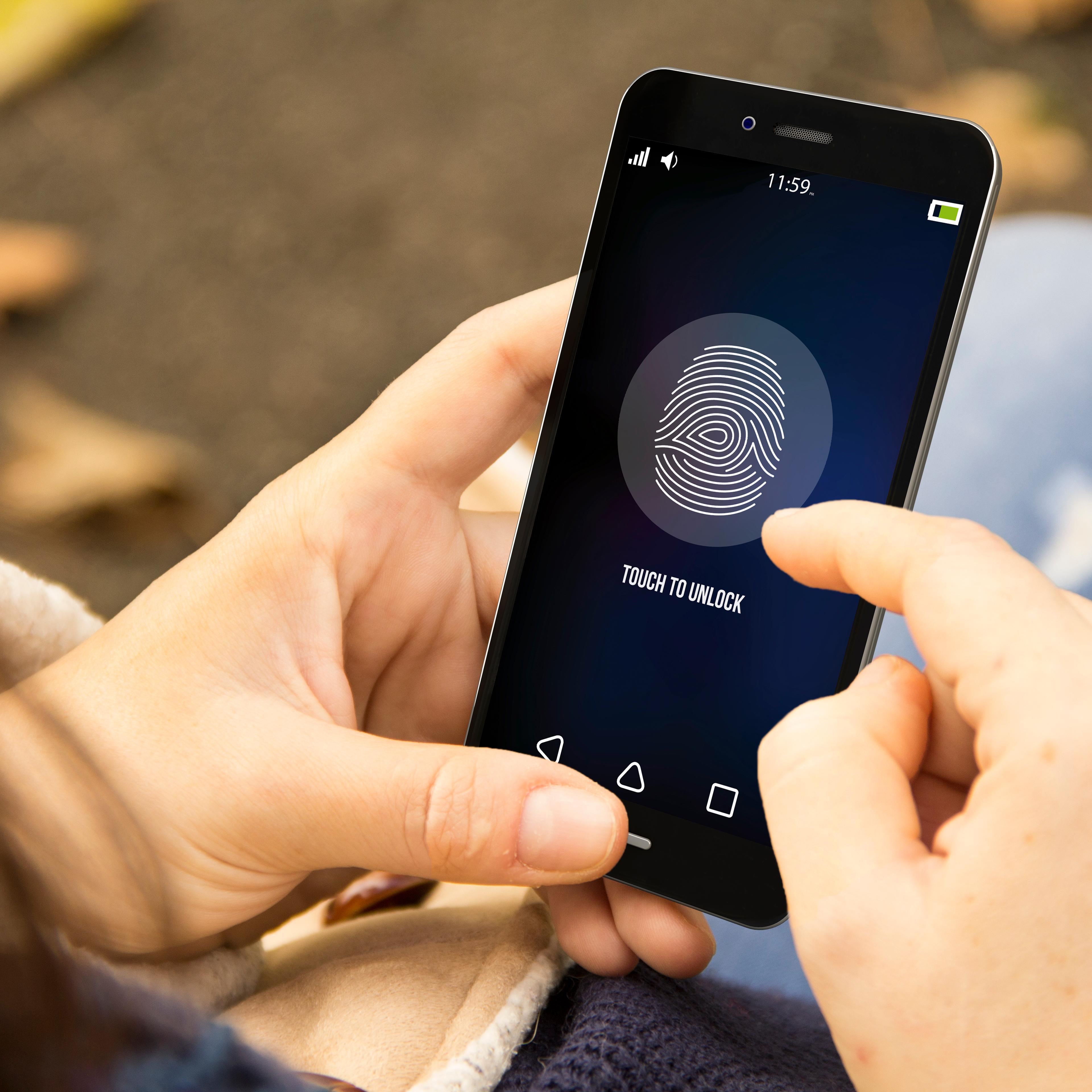 woman unlocking phone in the park