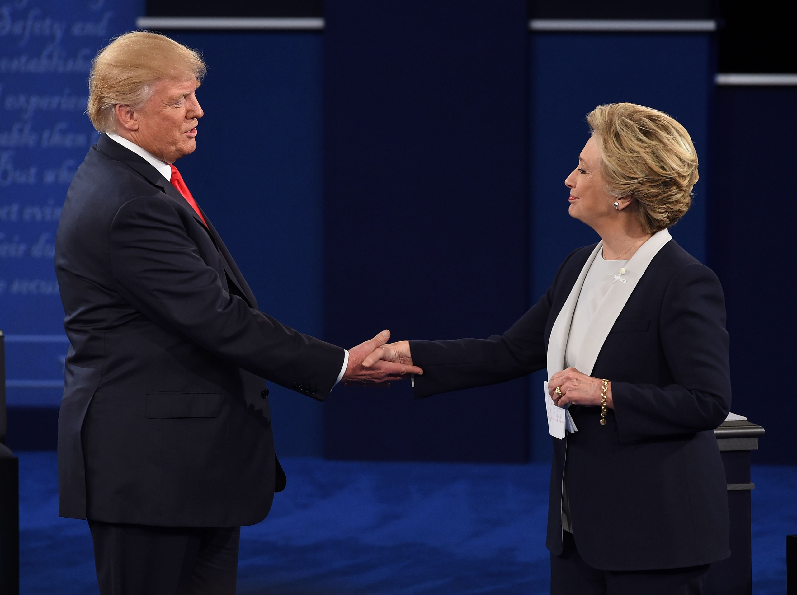 US Democratic presidential candidate Hillary Clinton (R) and US Republican presidential candidate Donald Trump shake hands at the end of the second presidential debate at Washington University in St. Louis, Missouri, on October 9, 2016. / AFP PHOTO / Rob