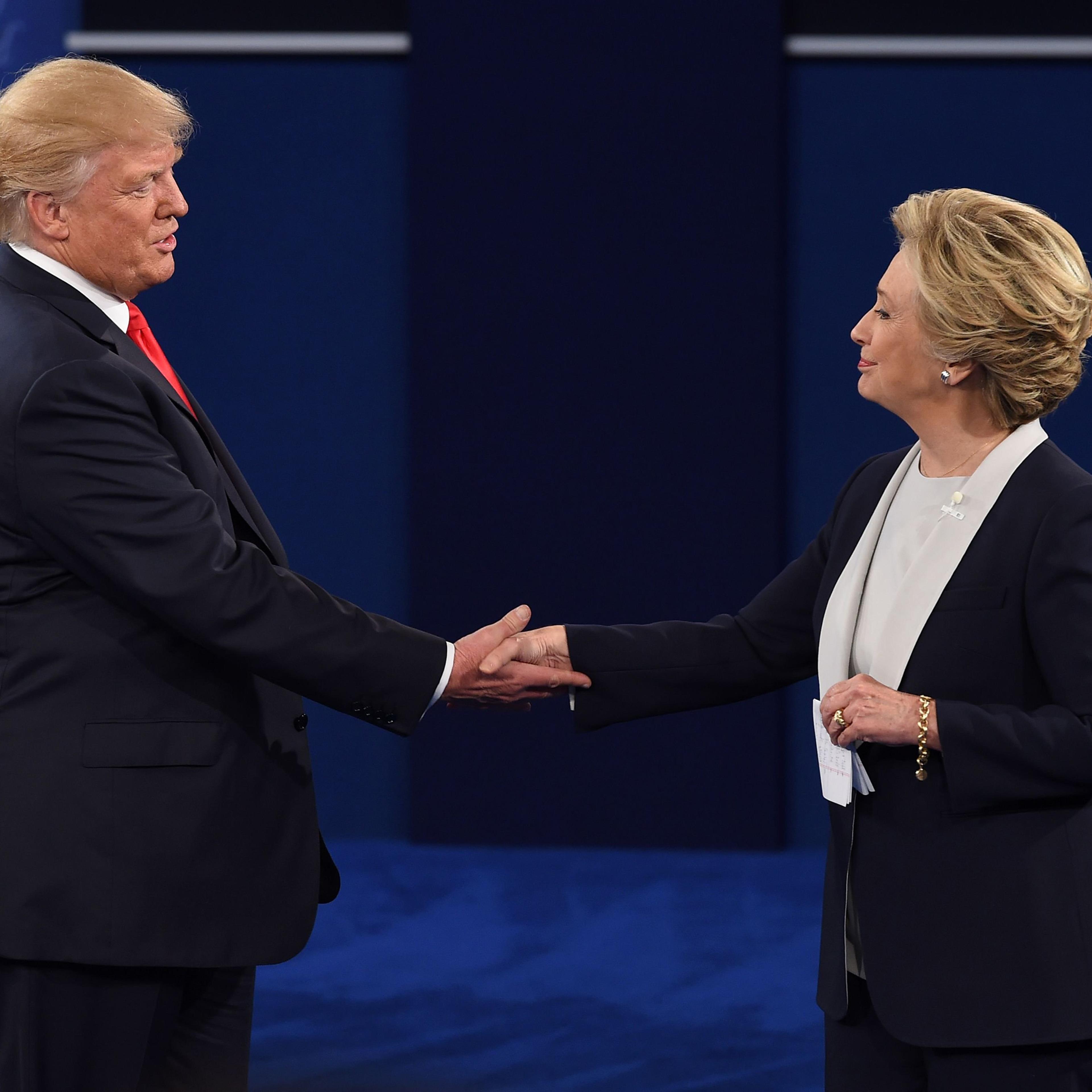 US Democratic presidential candidate Hillary Clinton (R) and US Republican presidential candidate Donald Trump shake hands at the end of the second presidential debate at Washington University in St. Louis, Missouri, on October 9, 2016. / AFP PHOTO / Rob