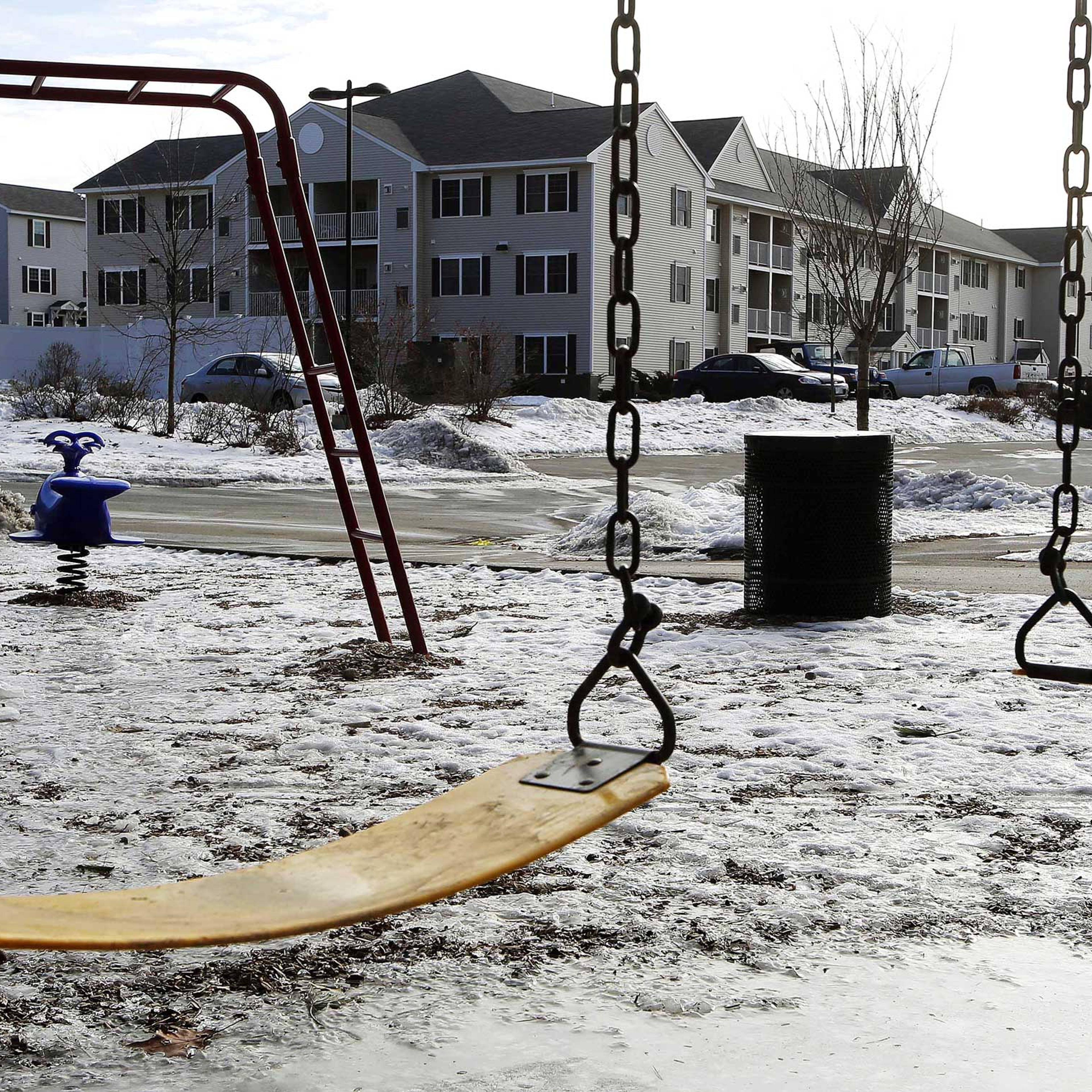 An empty playground is seen at an apartment complex, Jan. 22, 2015, in Manchester, N.H. where authorities say twin 9-year-old boys were left mostly alone for four months after their parents took three siblings to Nigeria and left an uncle to care for the