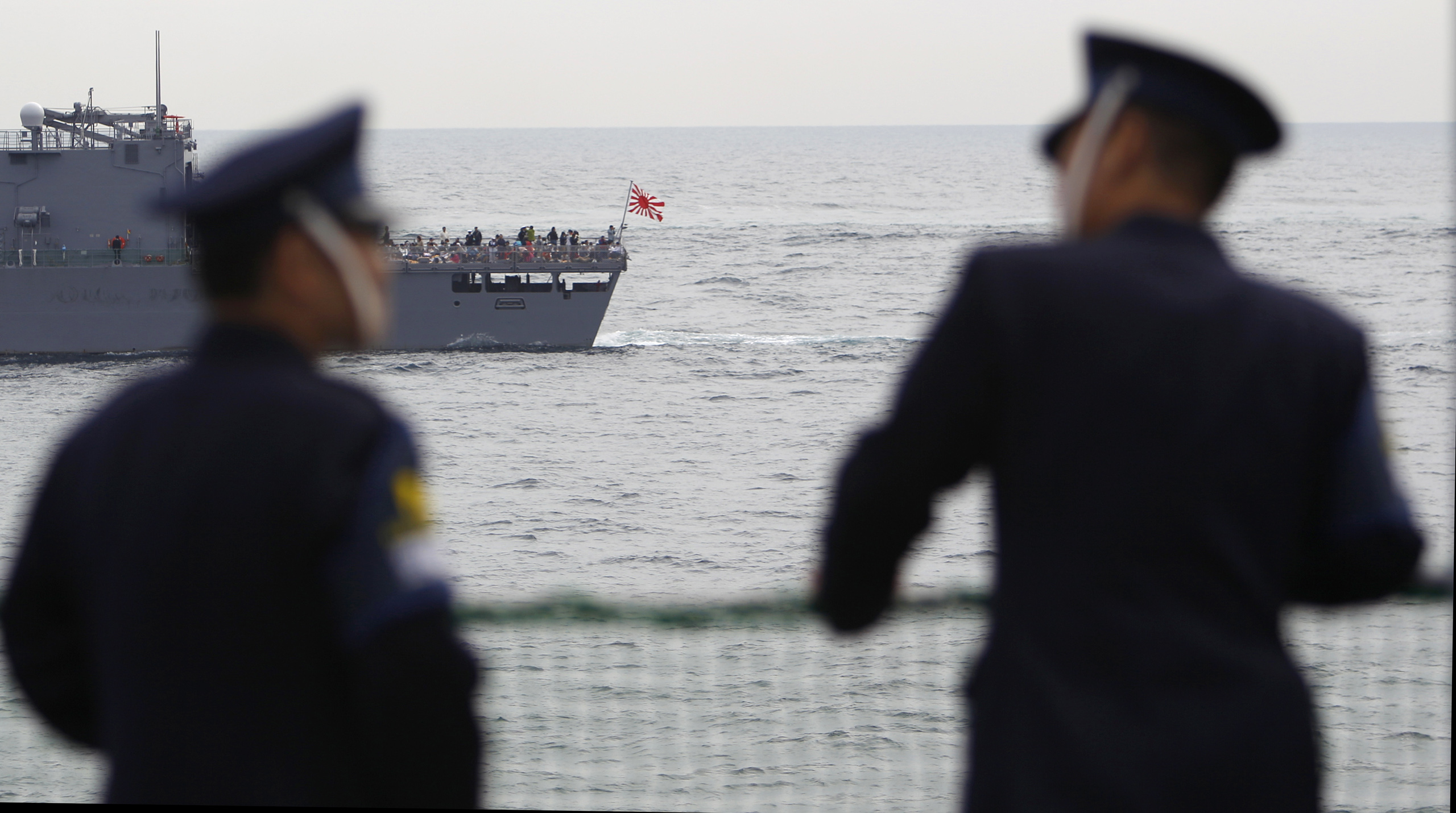 Members of Japan's Maritime Self-Defense Force watch a Japanese vessel during an event held ahead of the official triennial naval fleet review off Sagami Bay, south of Tokyo, Oct. 15, 2015.
