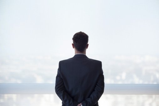 businessman-looking-out-window-rear-view