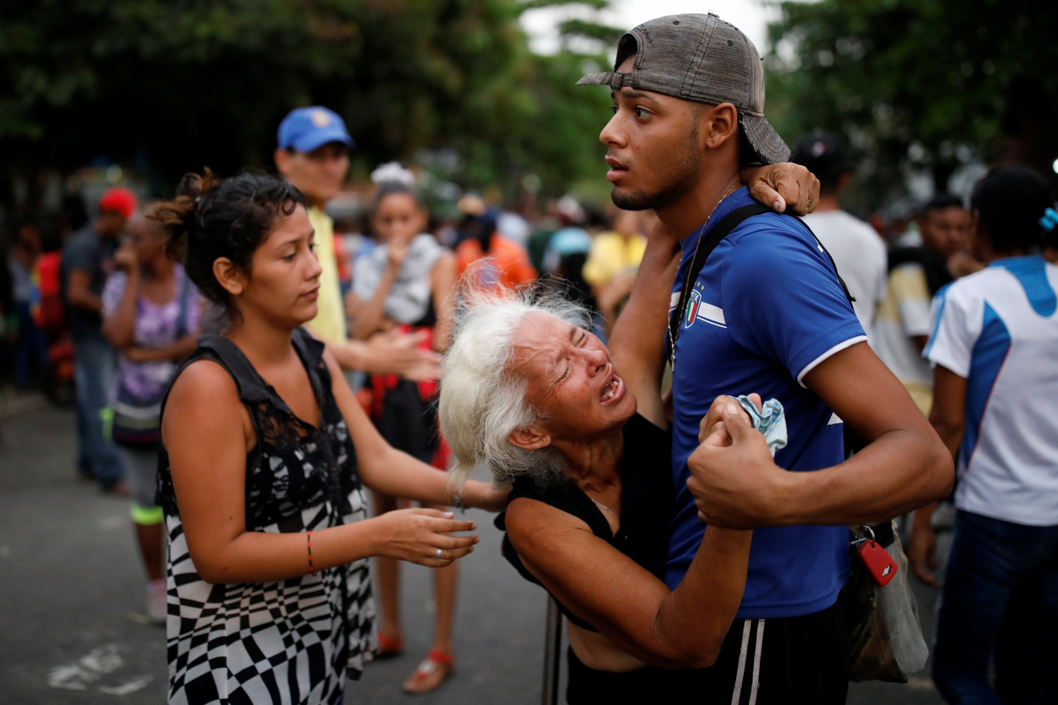 Relatives of inmates held at the General Command of the Carabobo Police react as they wait outside the prison where a fire occurred in Valencia