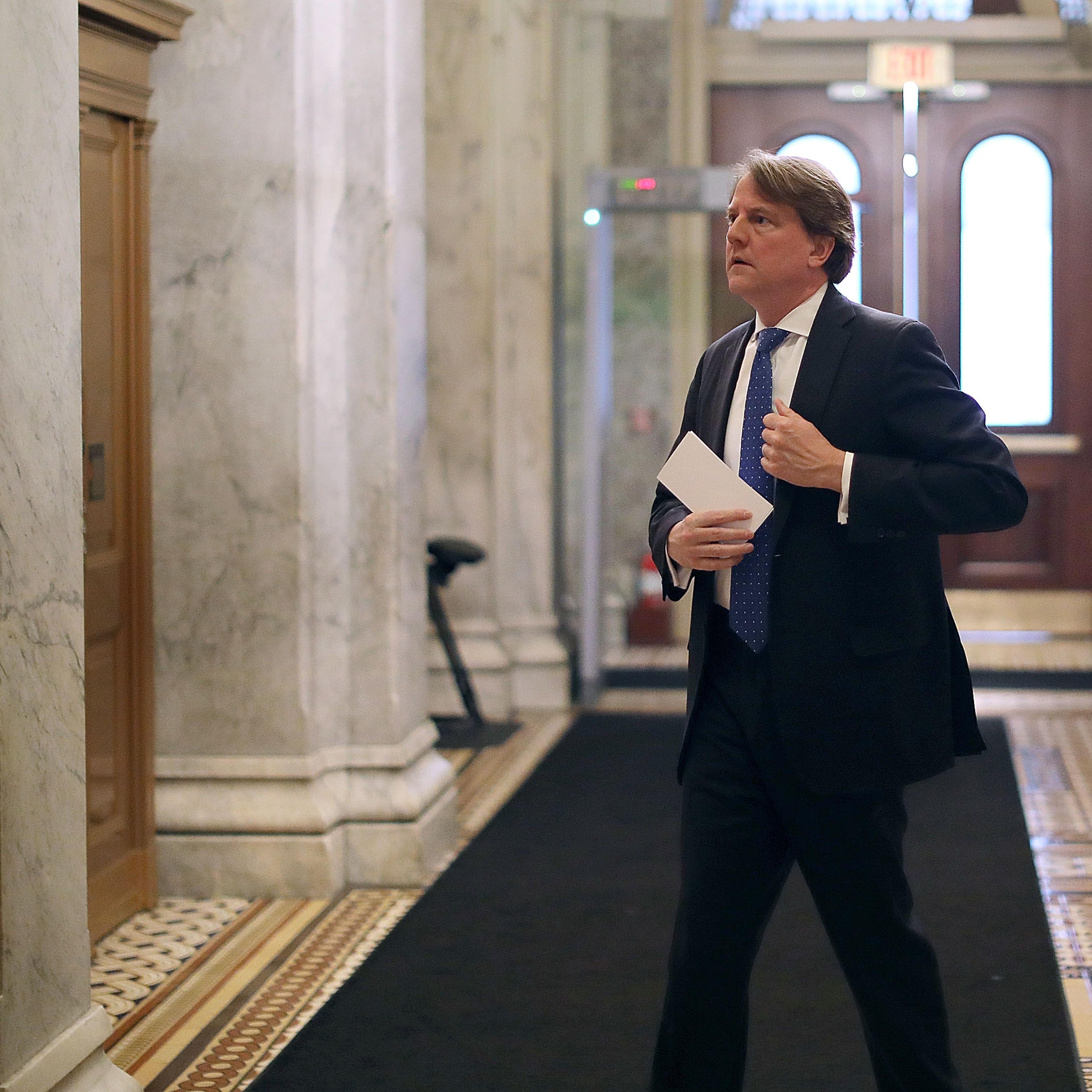 McGahn putting an envelope in his jacket