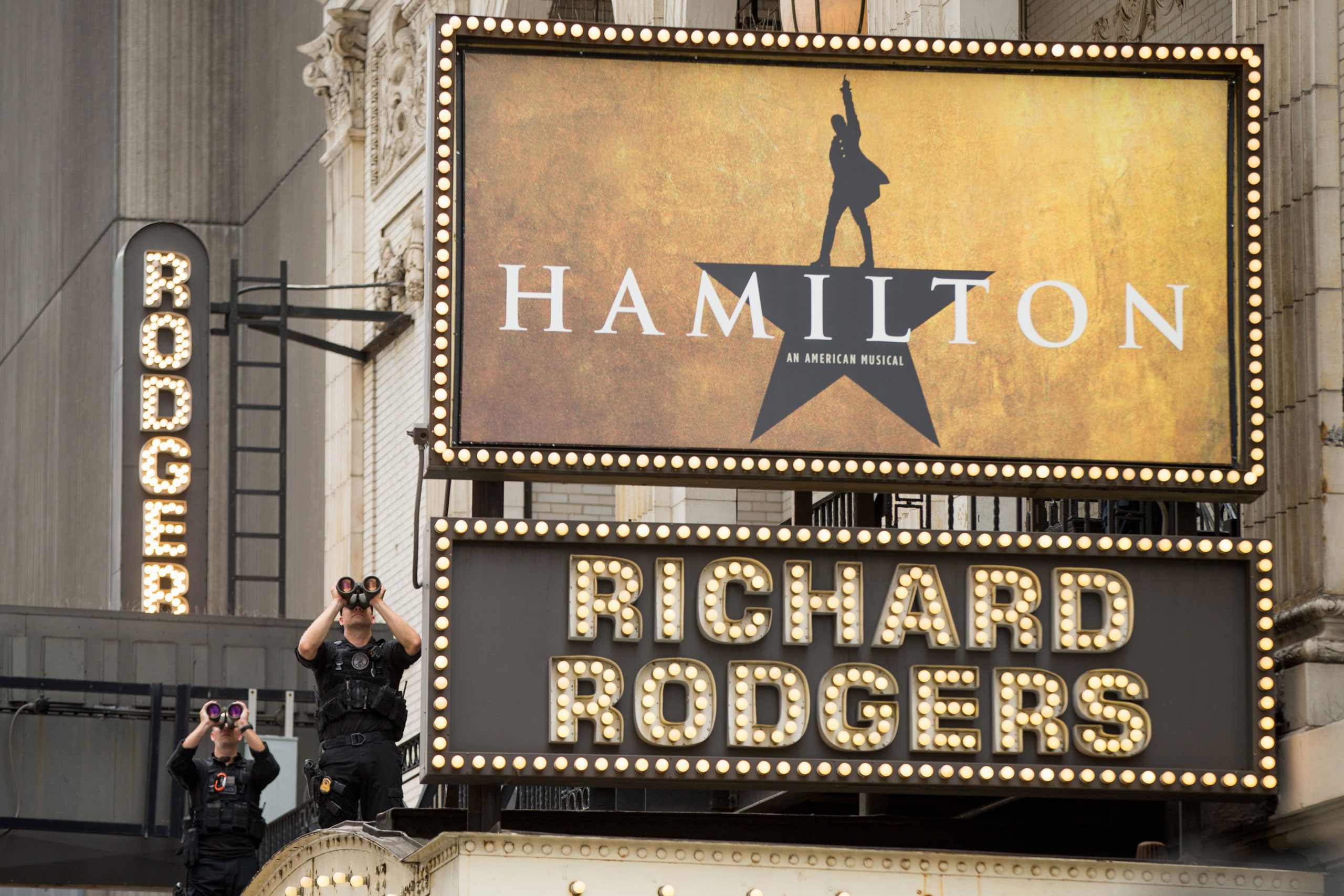 Secret Service officers stand on the awning of the Richard Rodgers Theatre in New York, Saturday, July 18, 2015, as President Barack Obama, daughters Sasha and Malia, his sister Maya Soetoro-Ng, her husband Konrad Ng, and friends attend a performance of 