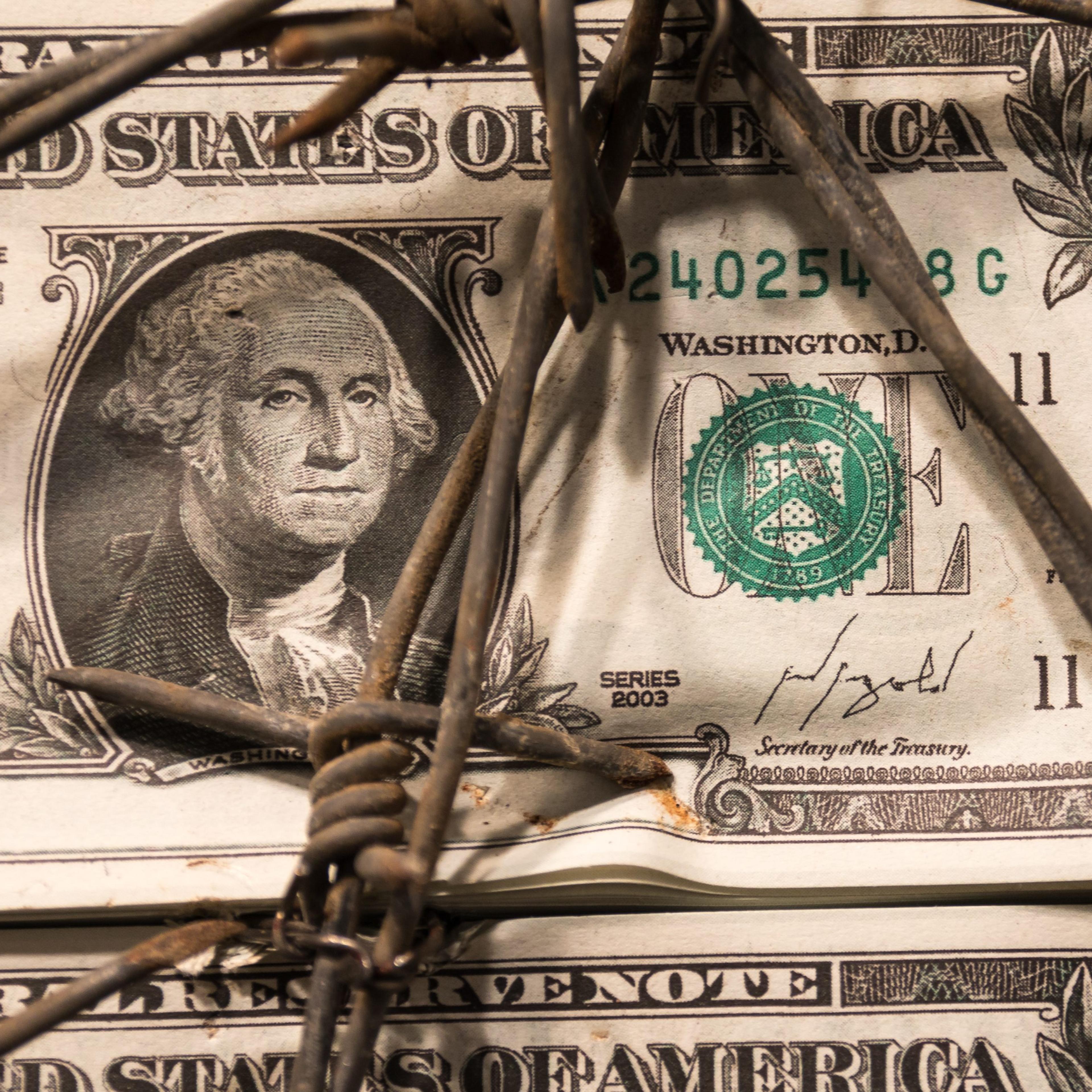 Closeup of Dollar Banknote with Barbed Wire