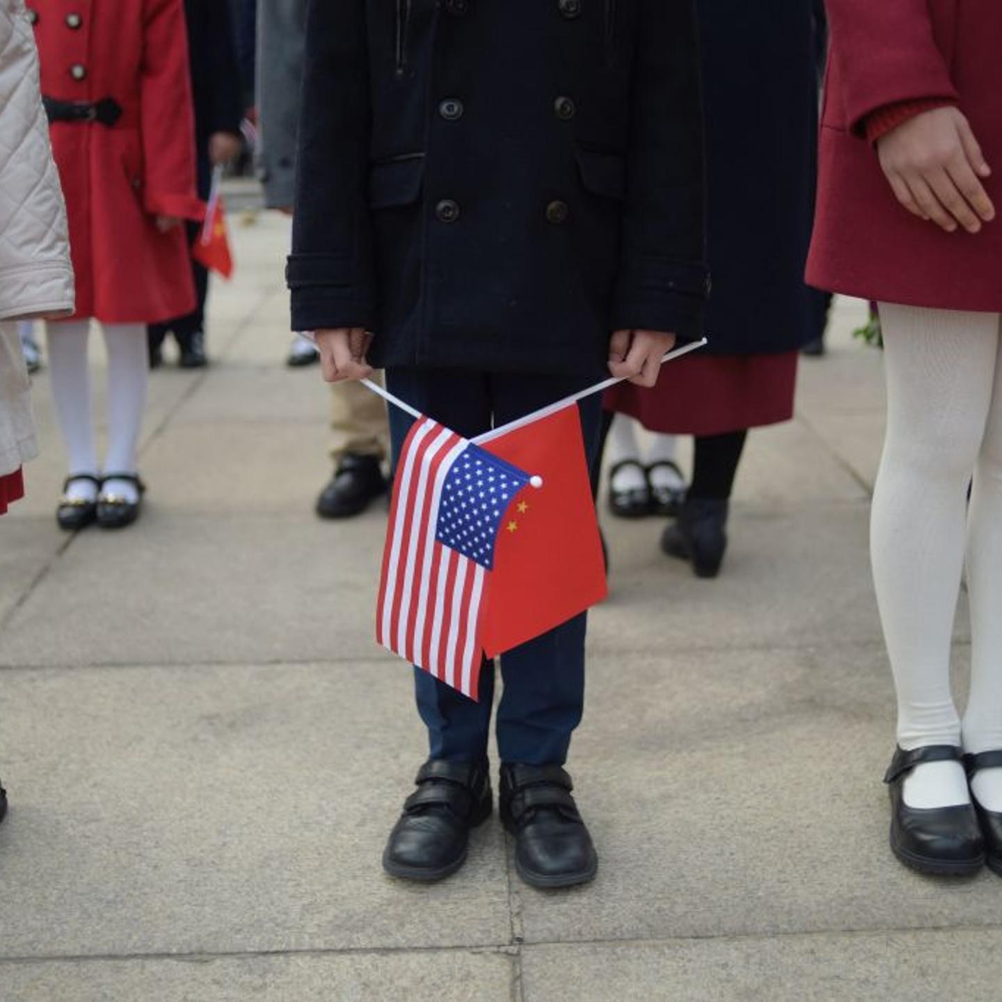 A child holds national flags during a welcome ceremony for China's President Xi Jinping and U.S. President Donald Trump at the Great Hall of the People in Beijing, China, on November 9, 2017.