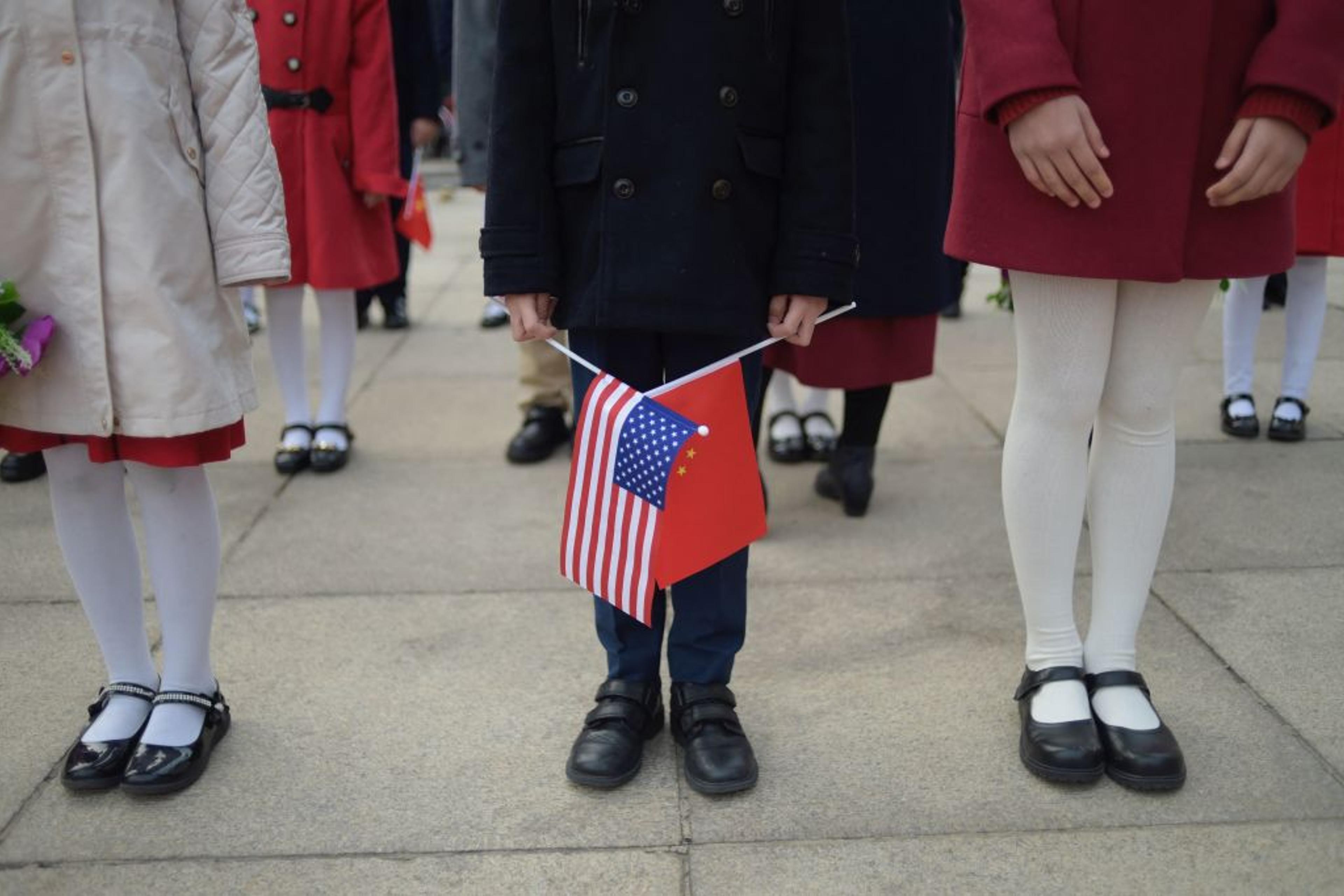 A child holds national flags during a welcome ceremony for China's President Xi Jinping and U.S. President Donald Trump at the Great Hall of the People in Beijing, China, on November 9, 2017.