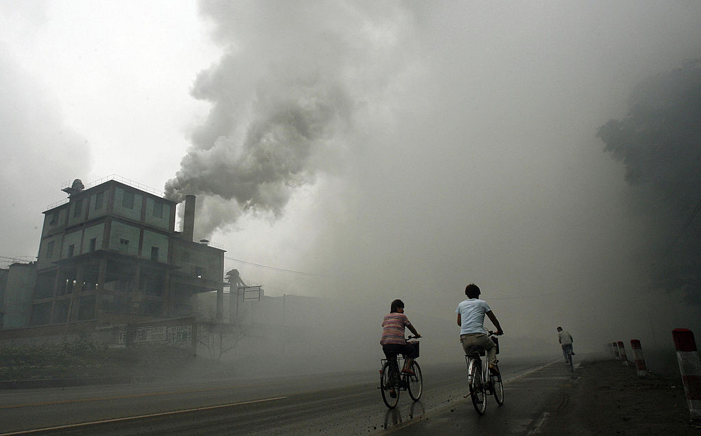 This 2006 picture shows cyclists passing through thick pollution from a factory in Yutian, east of Beijing in China's northwest Hebei province.