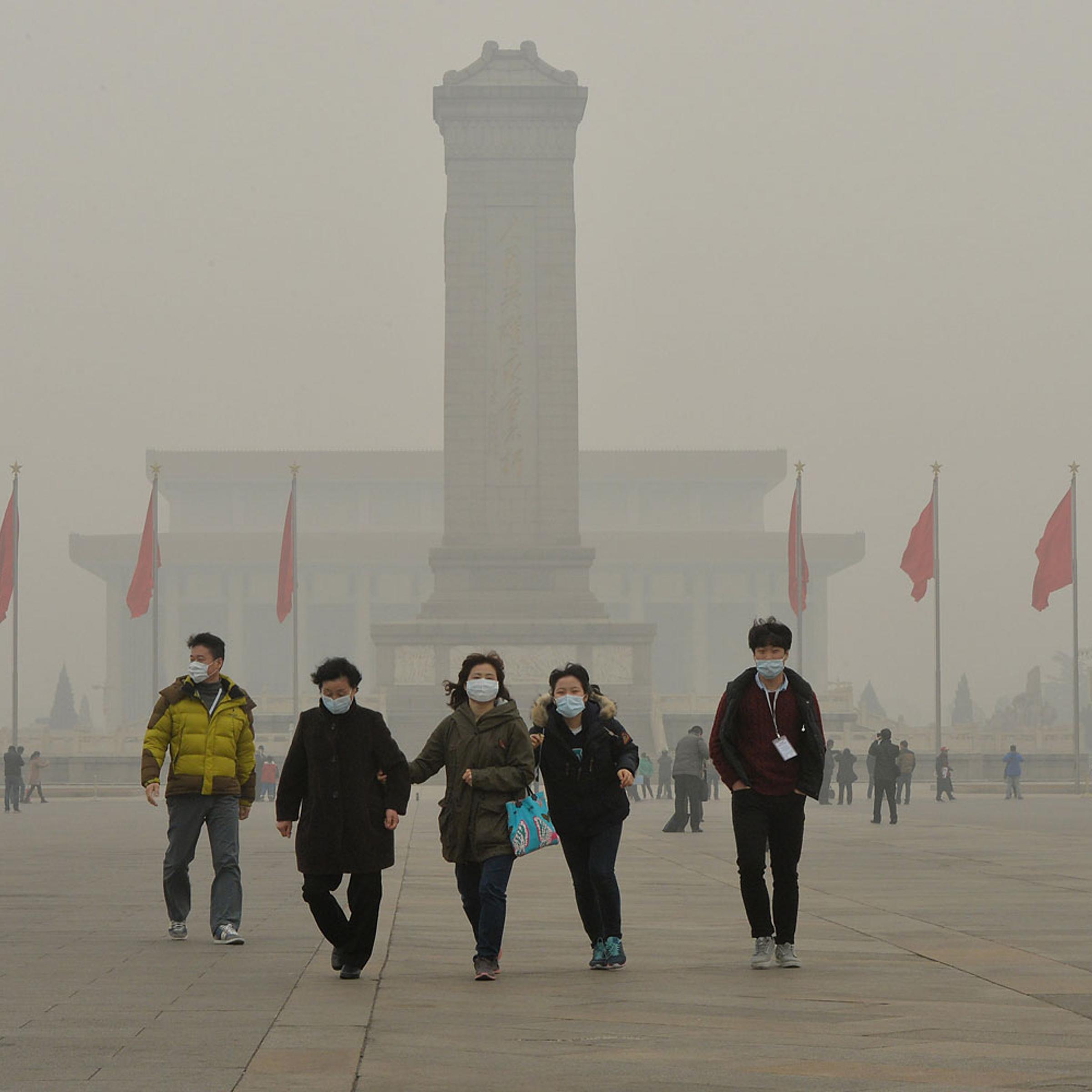 People wearing face masks visit Tiananmen Square as heavy air pollution shrouds Beijing on Feb. 26, 2014.