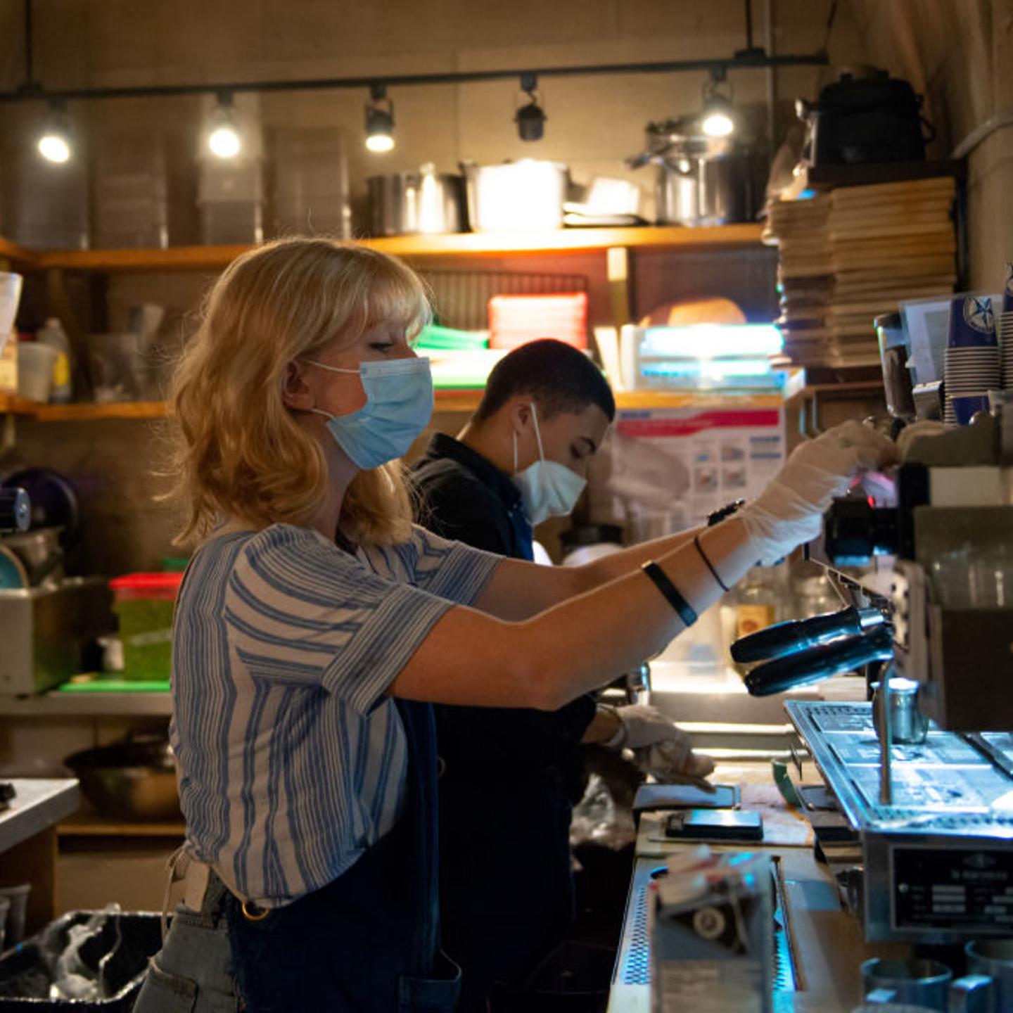 A barista wearing a mask prepares coffee on August 23, 2020, during New York's Phase 4 of re-opening following restrictions imposed to slow the spread of coronavirus