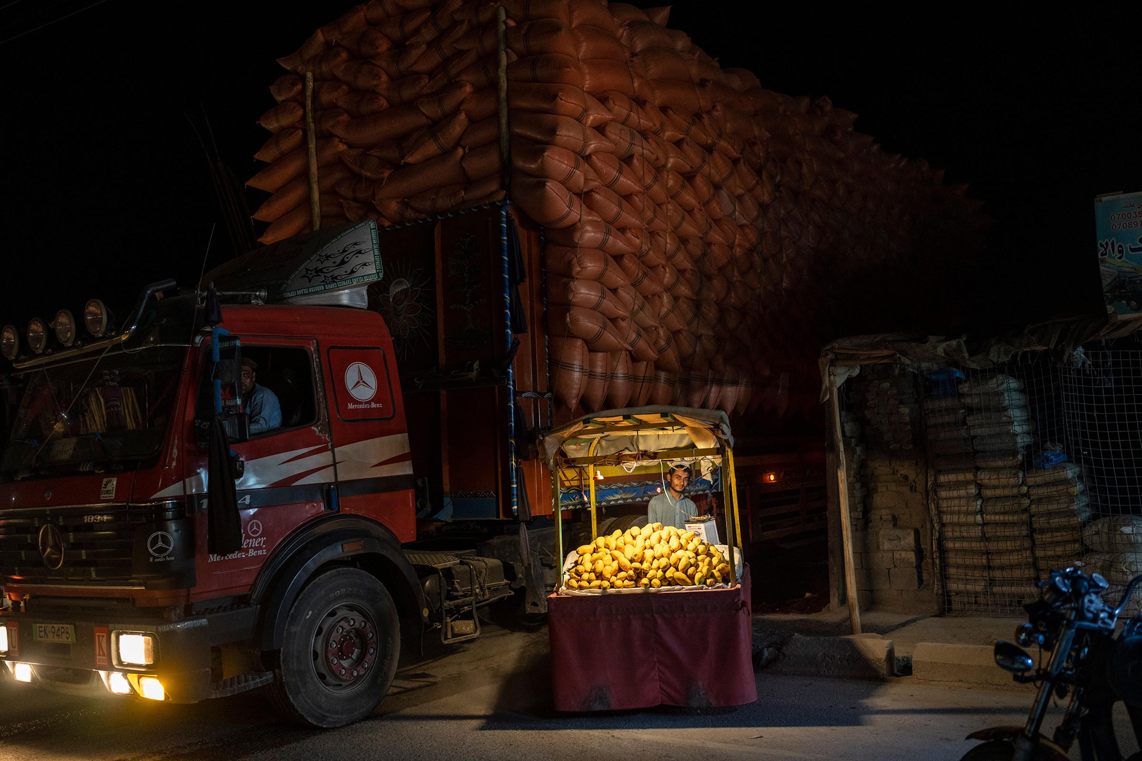 A man waits for clients while selling mangos in his street stall in the late afternoon in Kandahar City, Afghanistan, on June 12.
