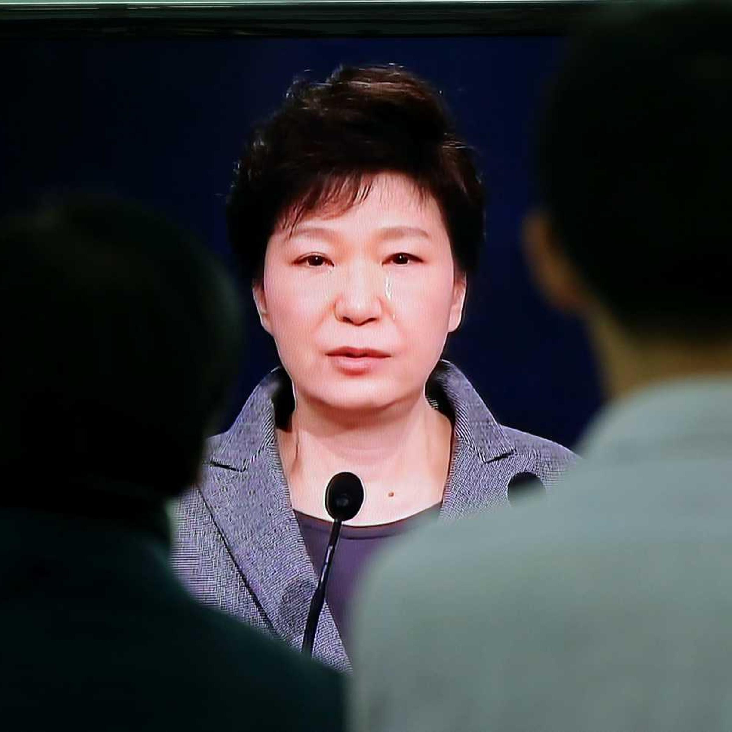 Passersby at a Seoul train station watch a live television broadcast of South Korean President Park Geun-hye's speech to the nation on the <i>Sewol</i> ferry tragedy on May 19, 2014