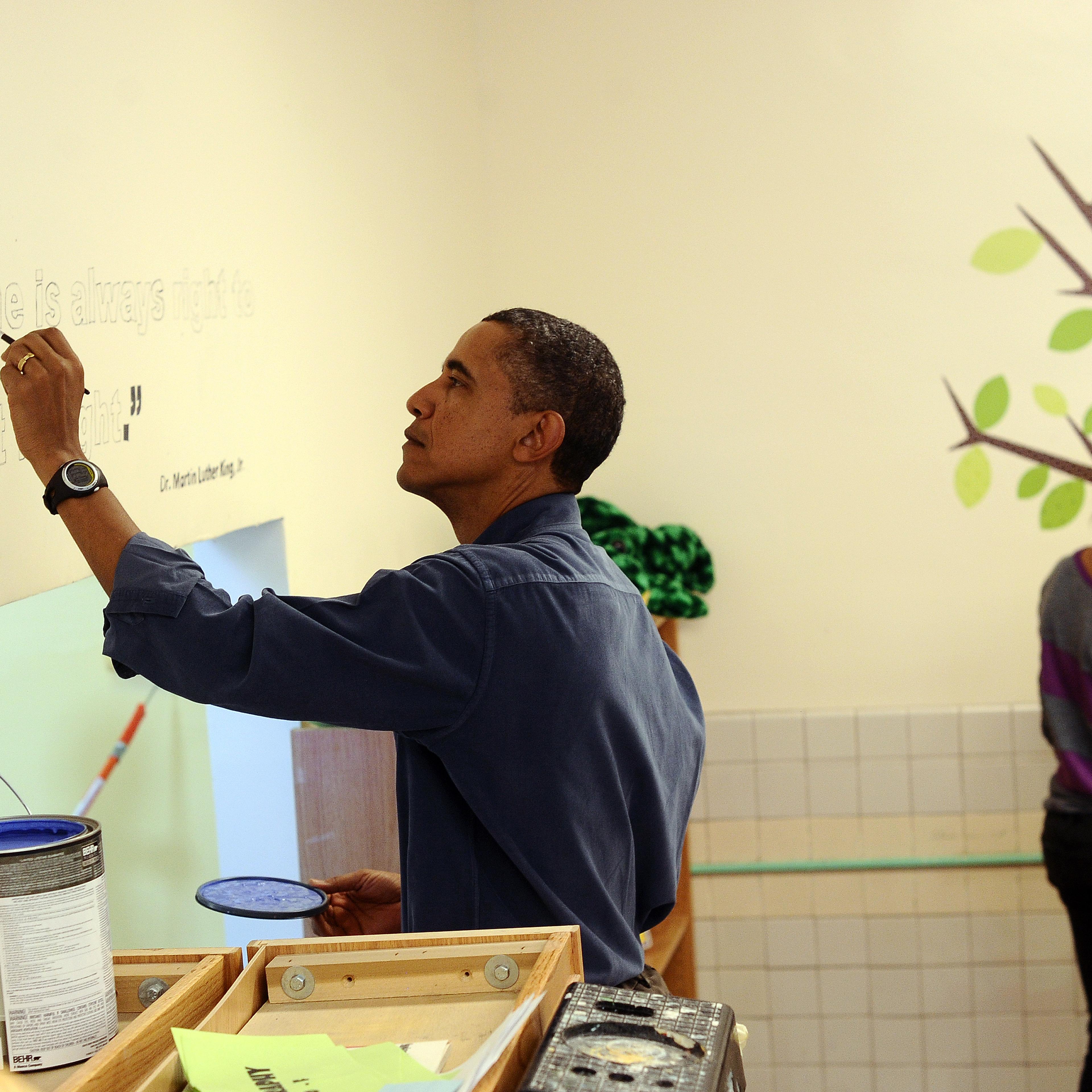 US President Barack Obama (L) paints a q