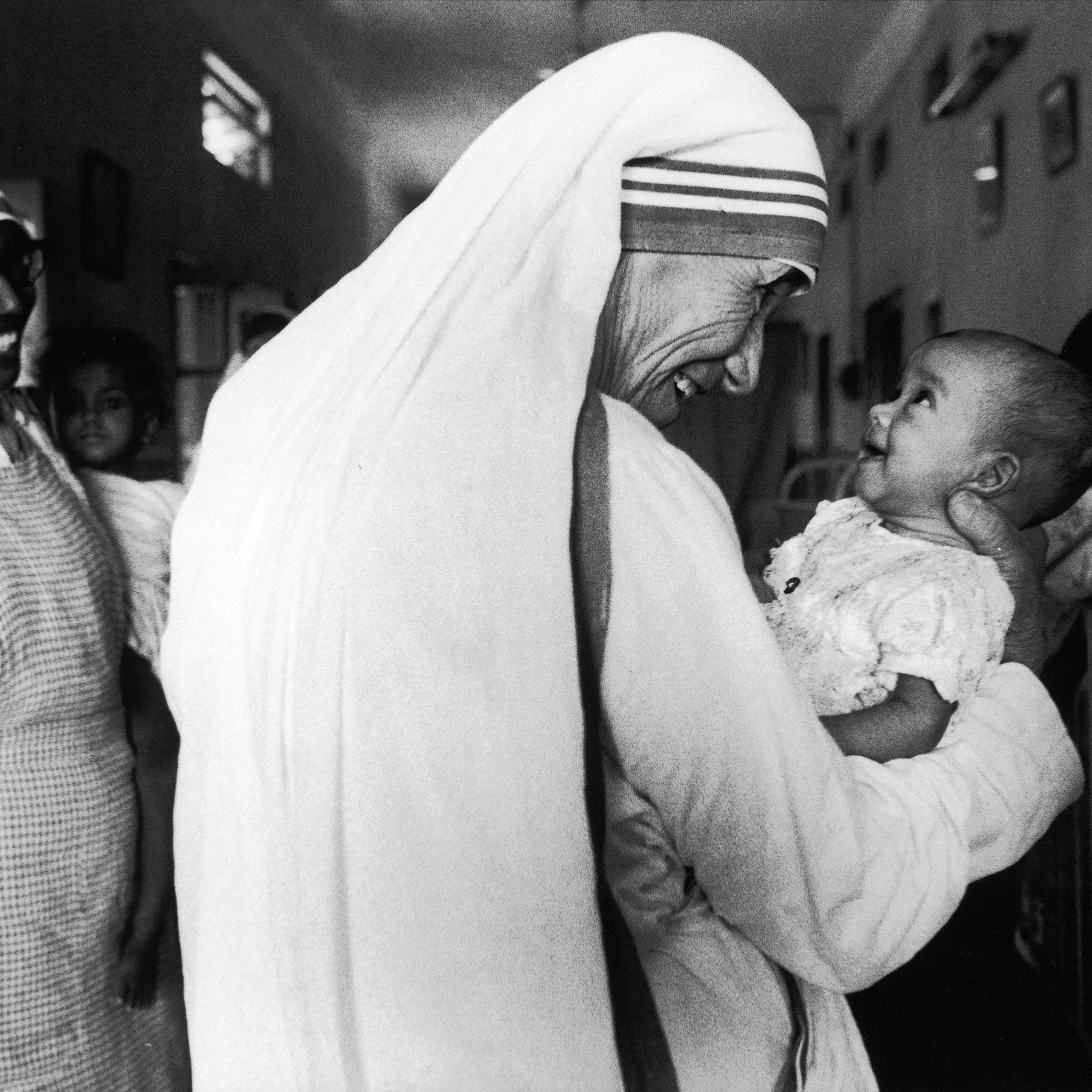 Mother Teresa smiles with an infant in Calcutta, India, in 1981.