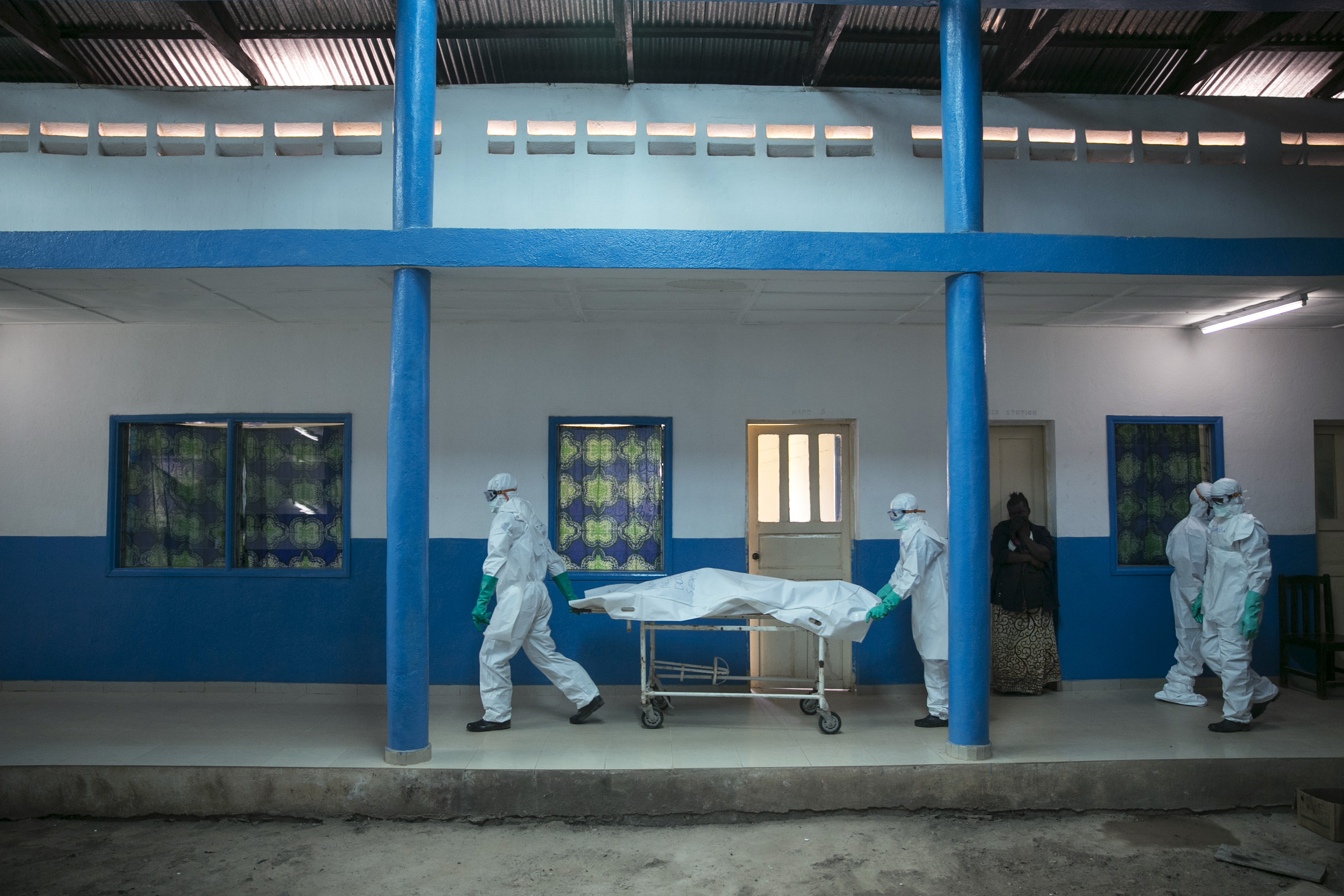 Health workers push a gurney with a dead body at a Red Cross facility in the town of Koidu, Kono district Eastern Sierra Leone on Dec. 19, 2014.