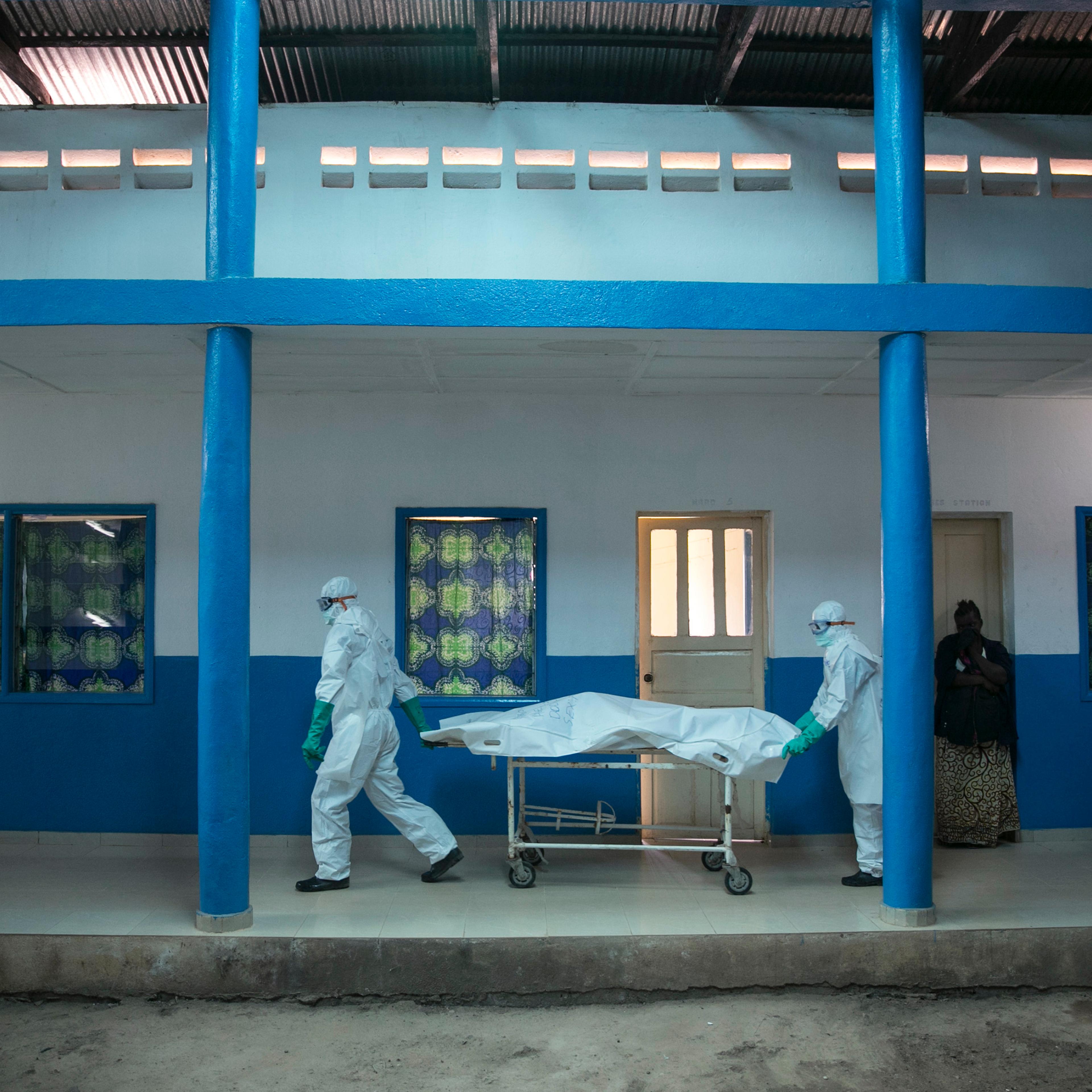 Health workers push a gurney with a dead body at a Red Cross facility in the town of Koidu, Kono district Eastern Sierra Leone on Dec. 19, 2014.