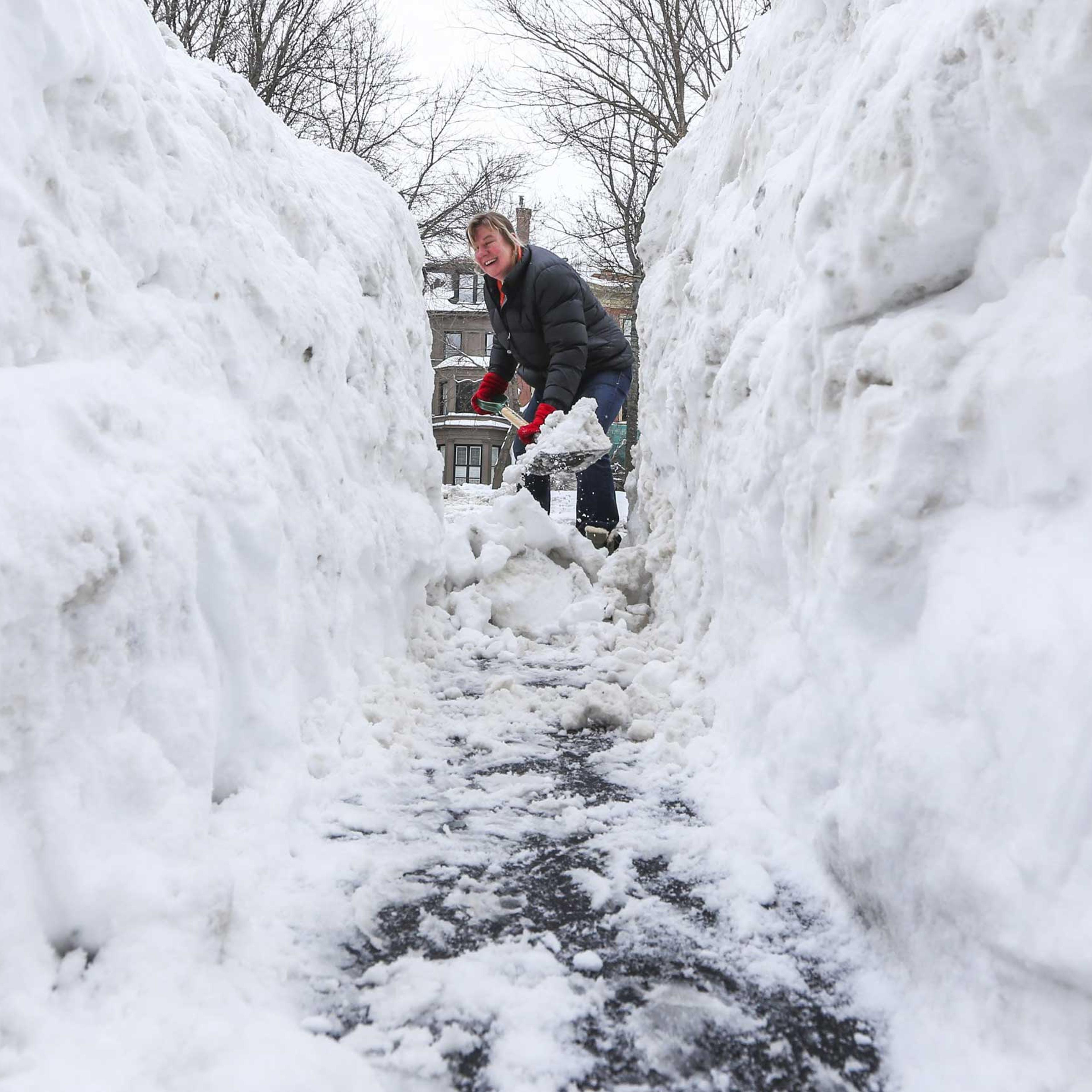 Ann Laborte shovels a path through the large mound of snow outside her Commonwealth Avenue home in Boston, Mass., Feb. 10, 2015.