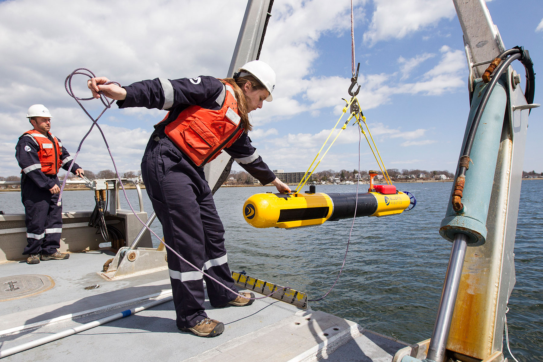 A submarine built by Bluefin Robotics is lowered into the water by a systems engineer in Quincy, Mass., April 9, 2014