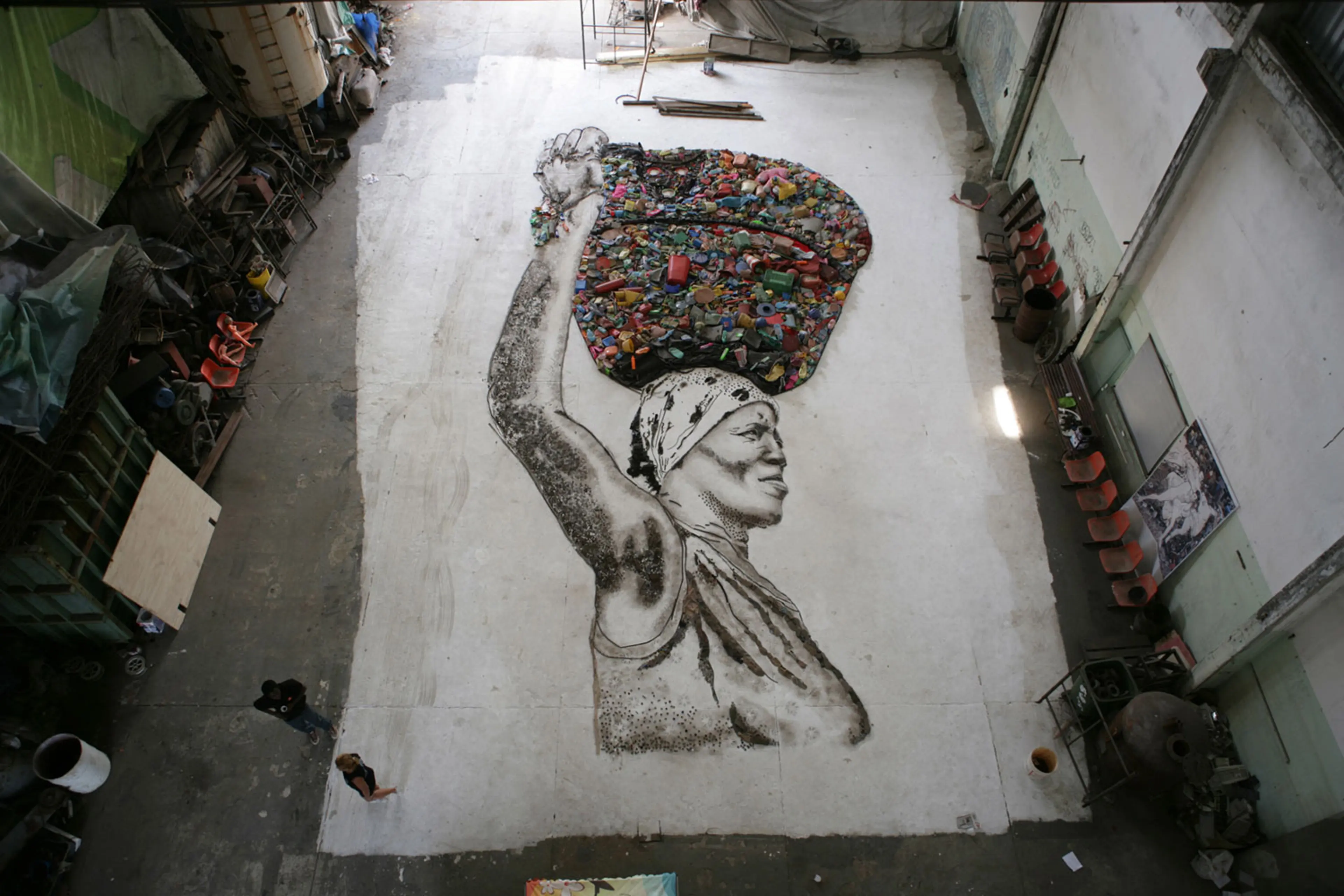 The portrait of Irma is created on the floor of the studio by Muniz and the workers of Jardim Gramacho. Once complete, the final portrait will be photographed from above by Muniz
