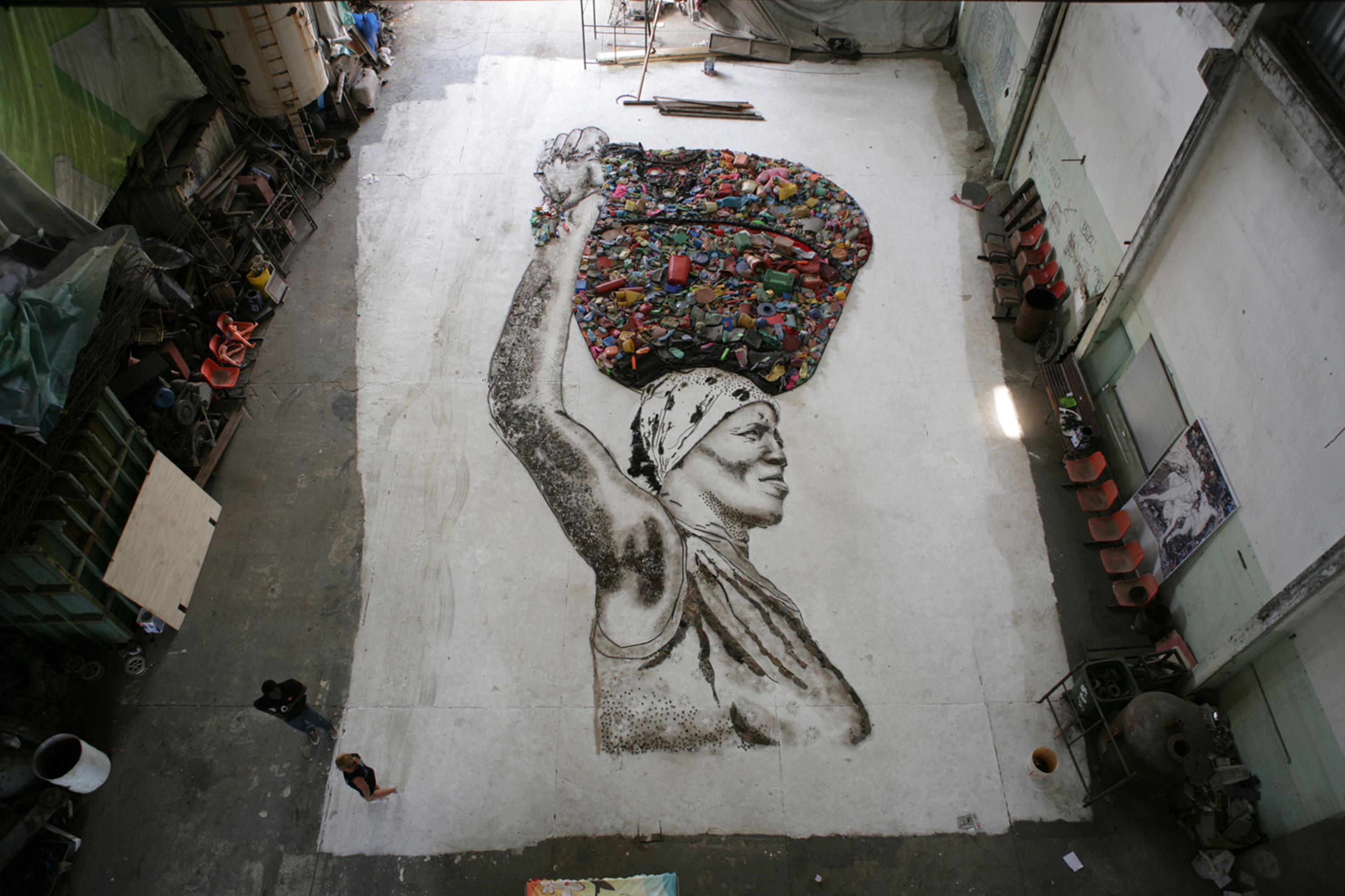 The portrait of Irma is created on the floor of the studio by Muniz and the workers of Jardim Gramacho. Once complete, the final portrait will be photographed from above by Muniz