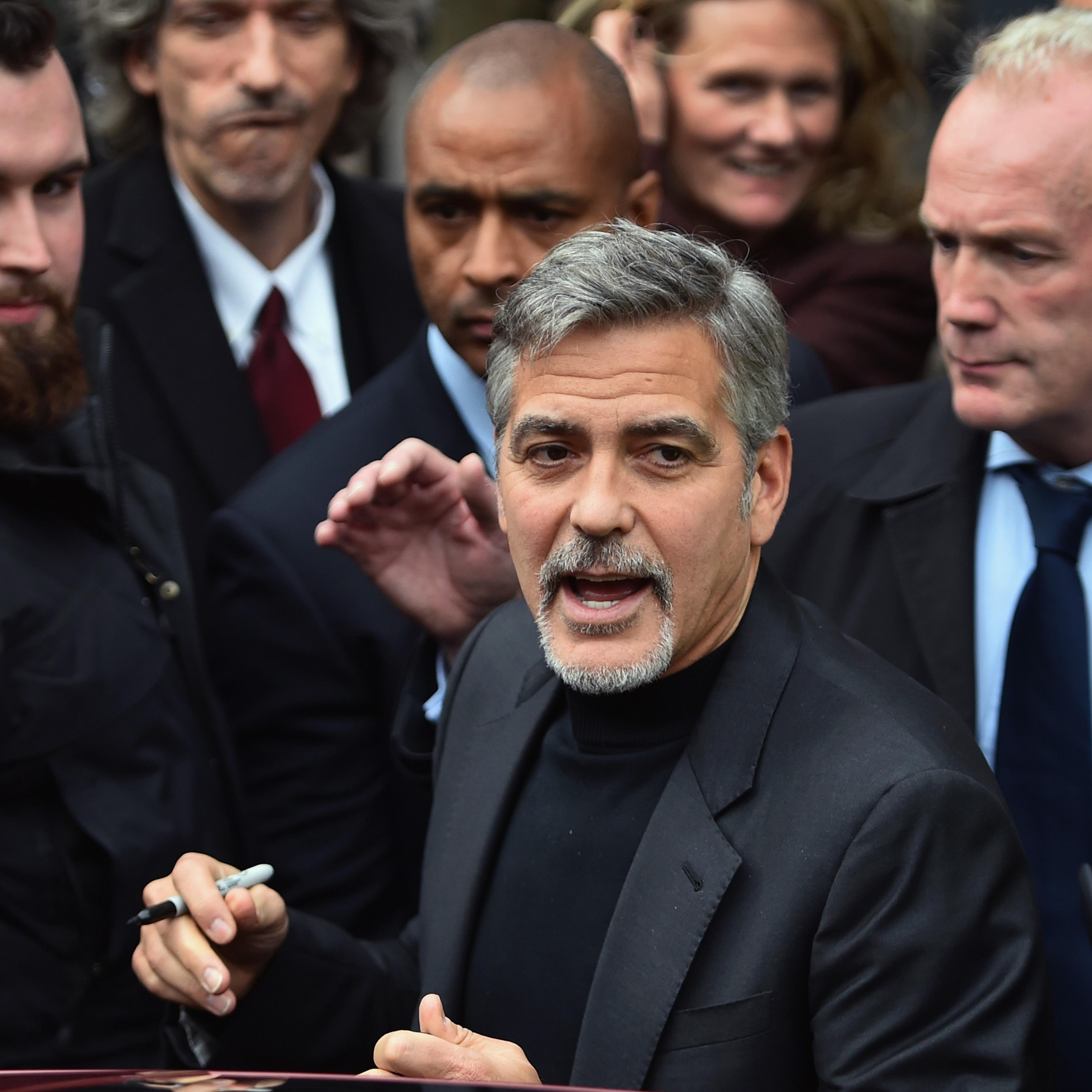 Hollywood actor George Clooney reacts with members of the public as he leaves Tiger Lily restaurant on Nov. 12, 2015 in Edinburgh, Scotland.