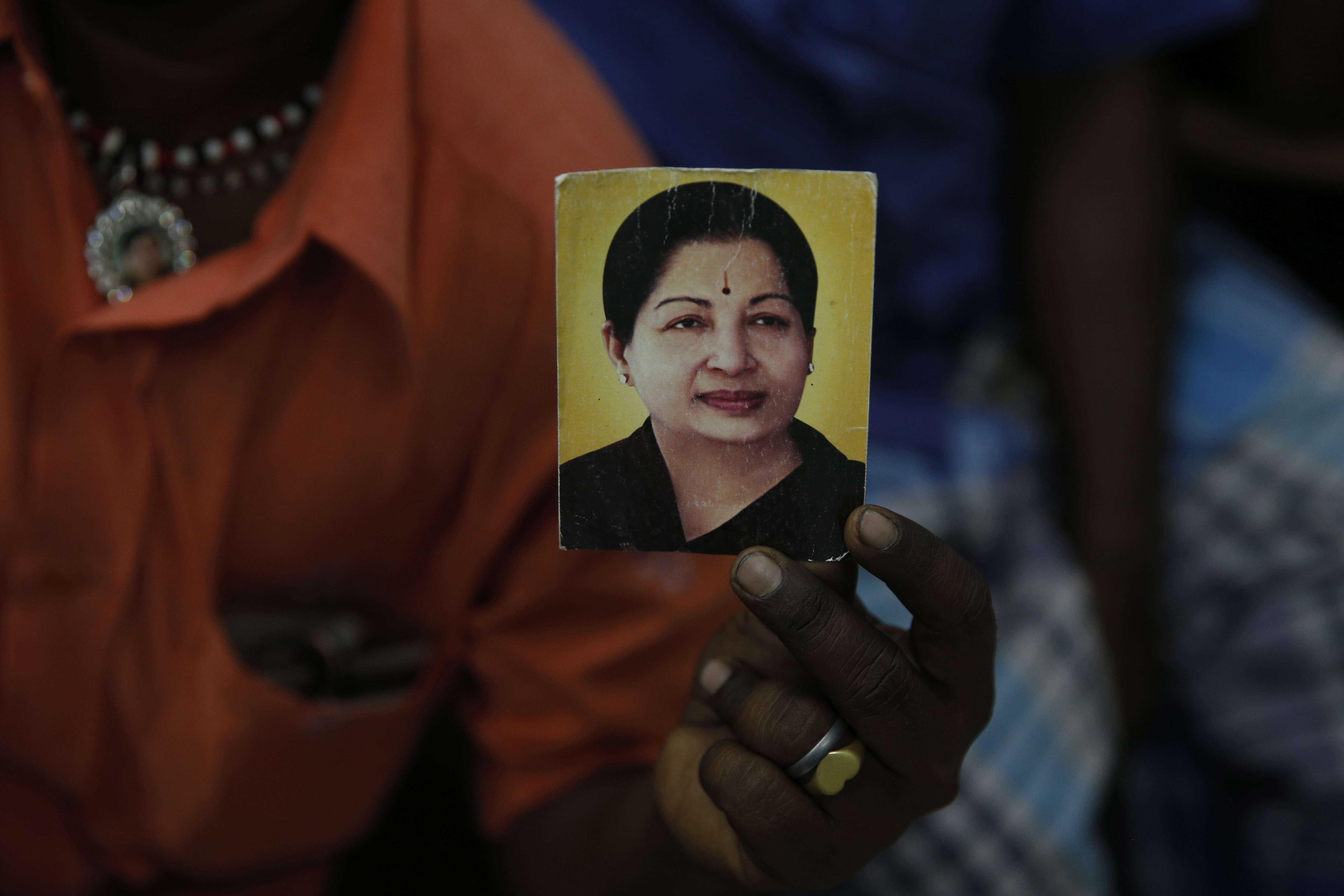A supporter of India's Tamil Nadu state Chief Minister Jayaram Jayalalithaa displays her photograph at their party office in Mumbai, Dec. 5, 2016.