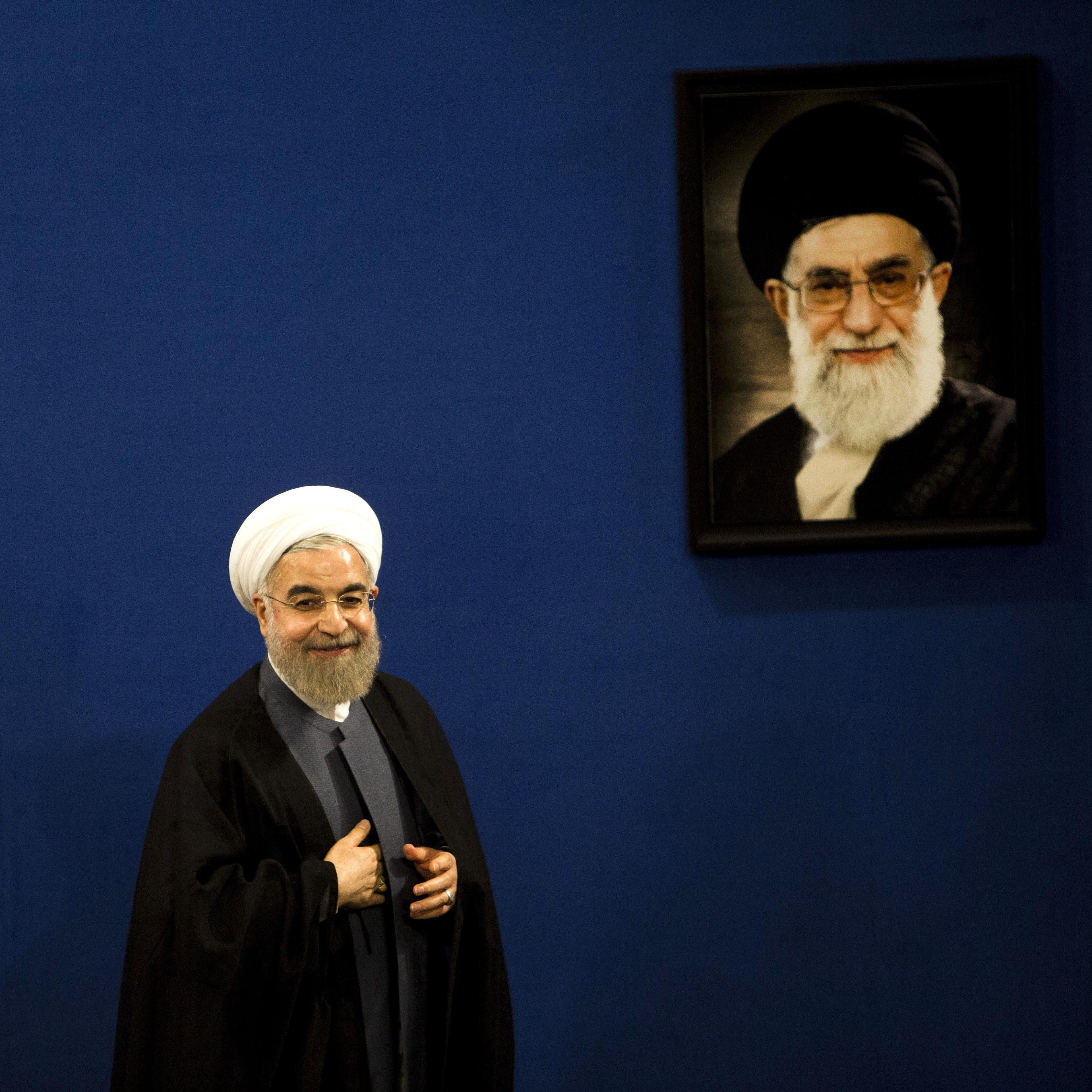 Iranian President Hassan Rouhani stands next to a portrait of supreme leader Ayatollah Ali Khamenei in Tehran on June 13, 2015.