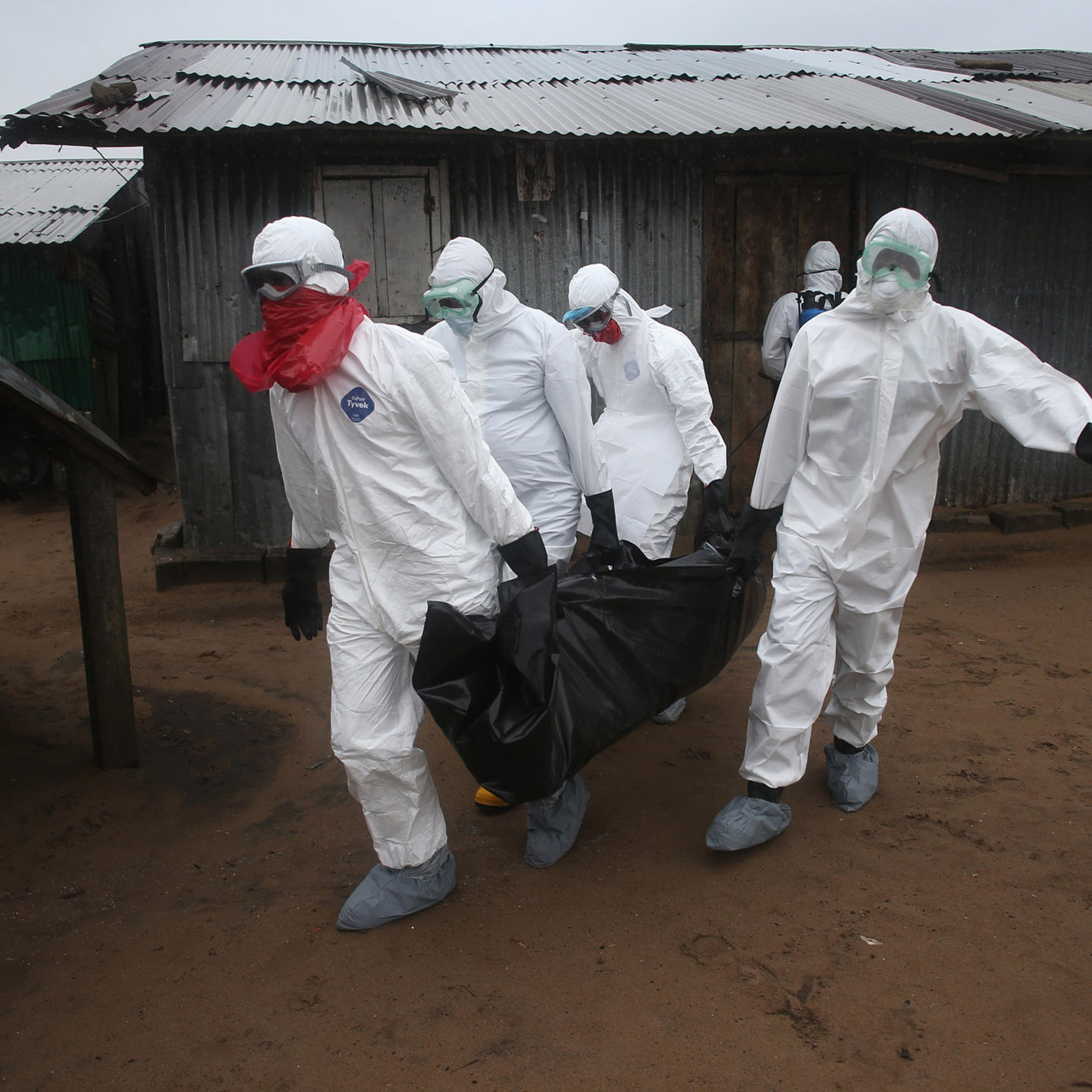 A Liberian burial team wearing protective clothing retrieves the body of a 60-year-old Ebola victim from his home on Aug. 17, 2014 near Monrovia, Liberia.