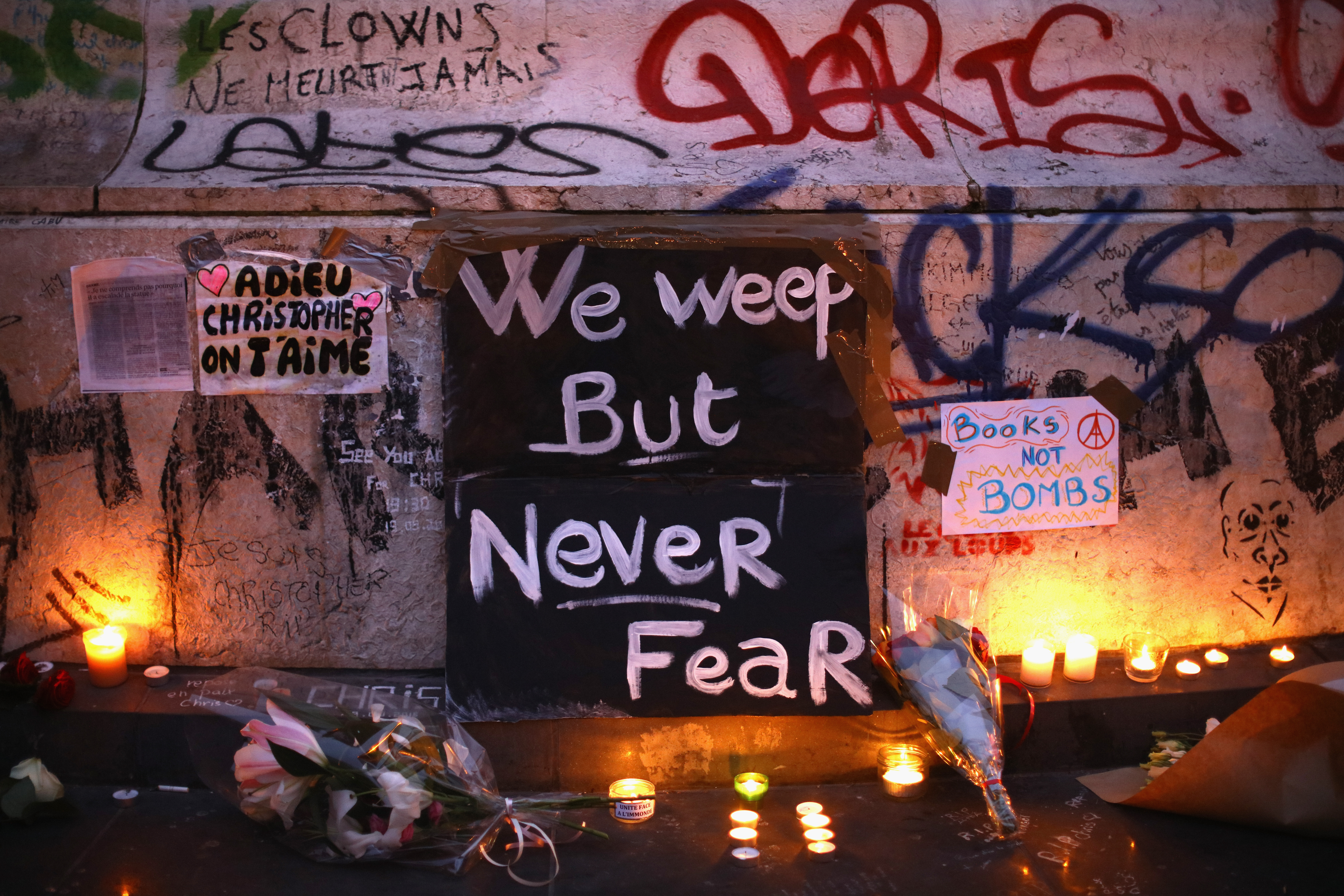 Parisians light candles and lay tributes on the monument at Place de la Republique, the day after deadly terrorist attacks in Paris on Nov. 14, 2015.