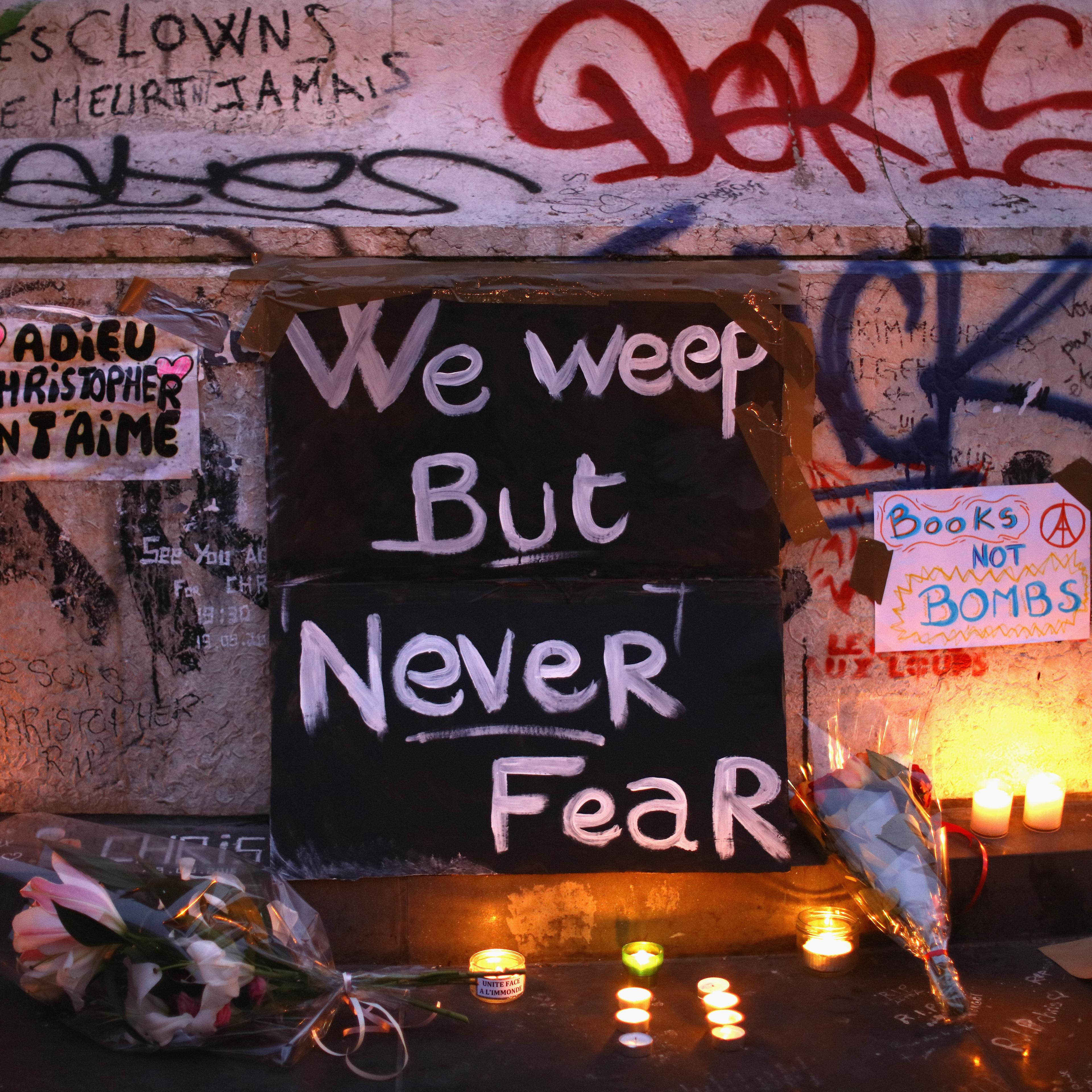 Parisians light candles and lay tributes on the monument at Place de la Republique, the day after deadly terrorist attacks in Paris on Nov. 14, 2015.