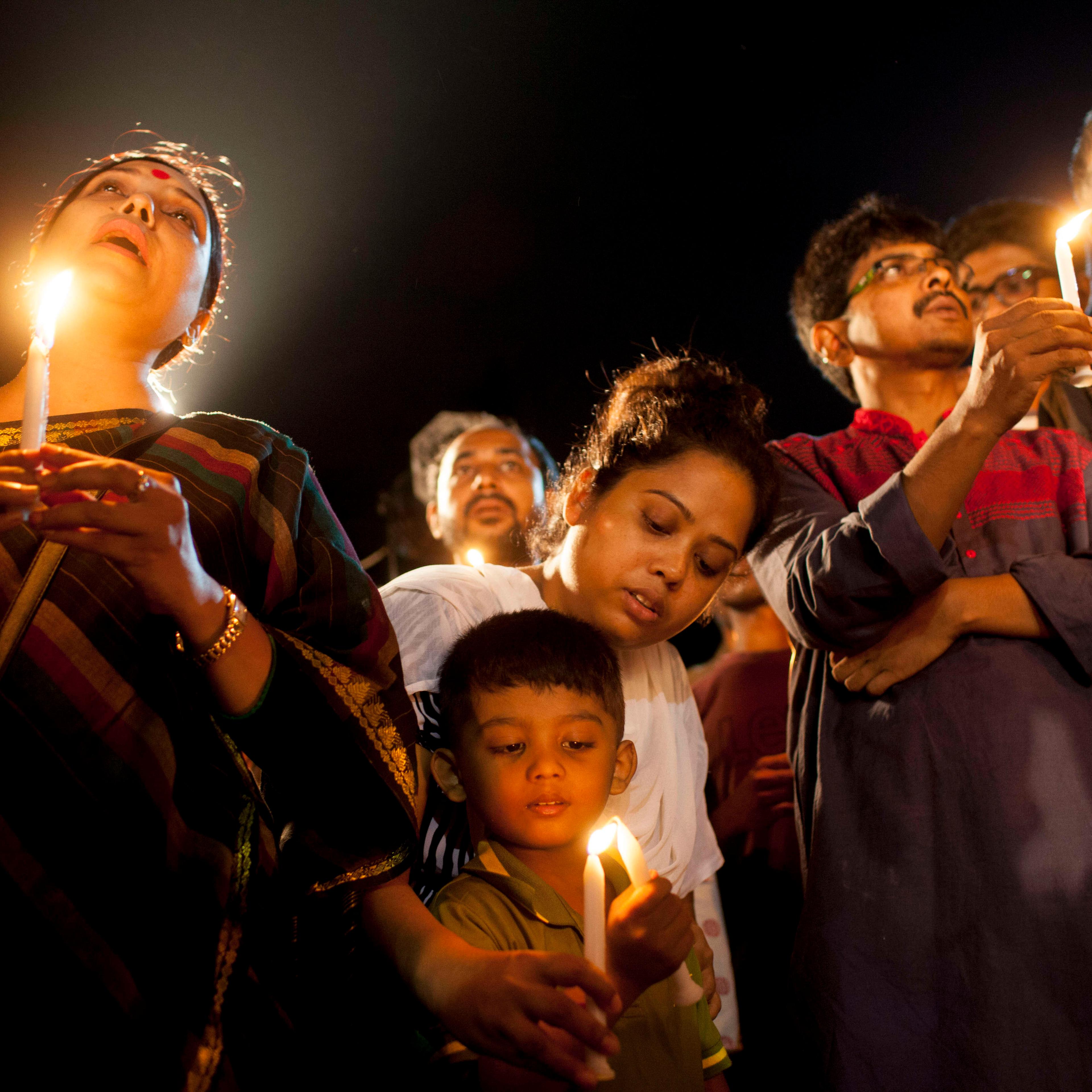 A boy with his family attends a candle-light ceremony to pay