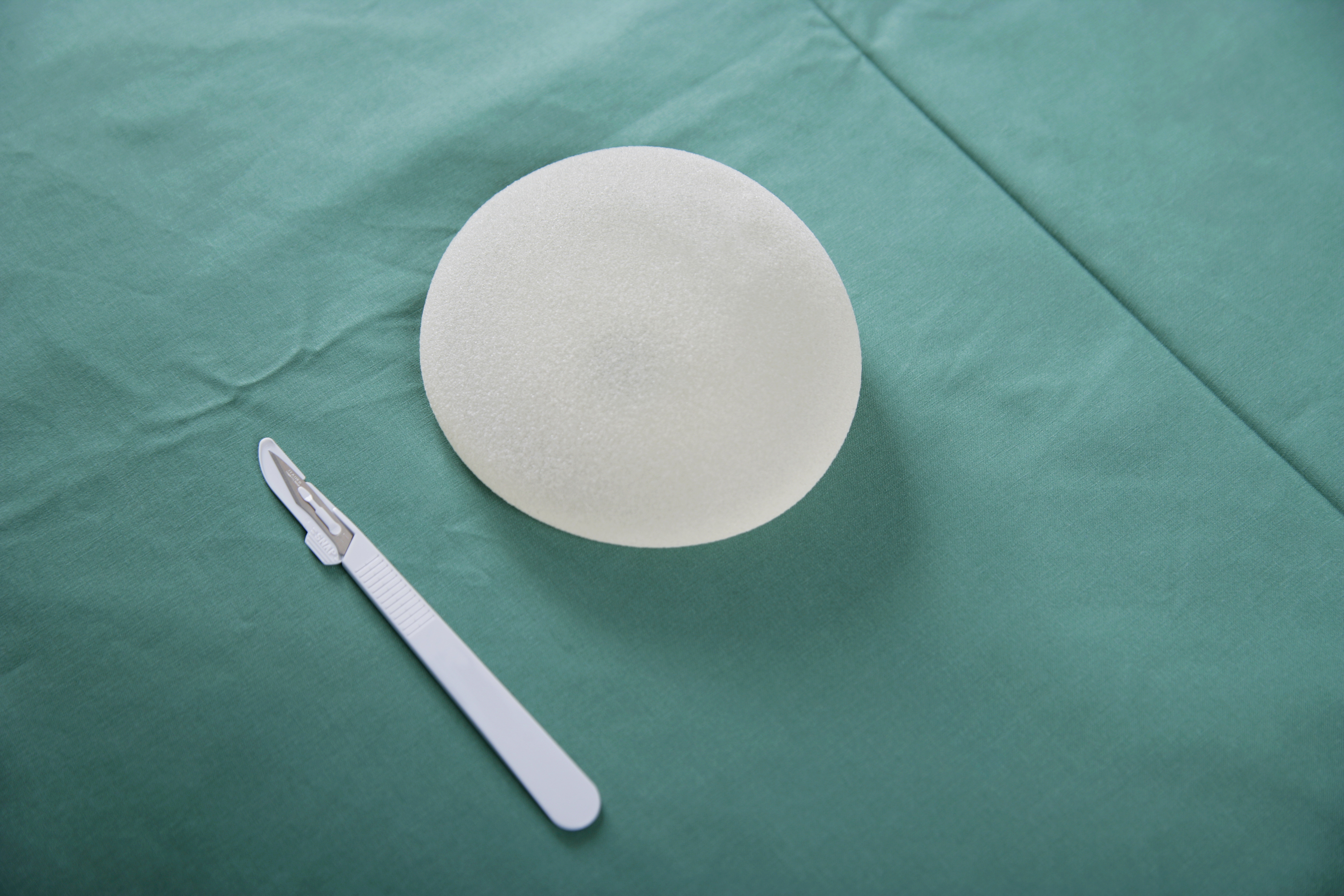 A breast implant and scalpel