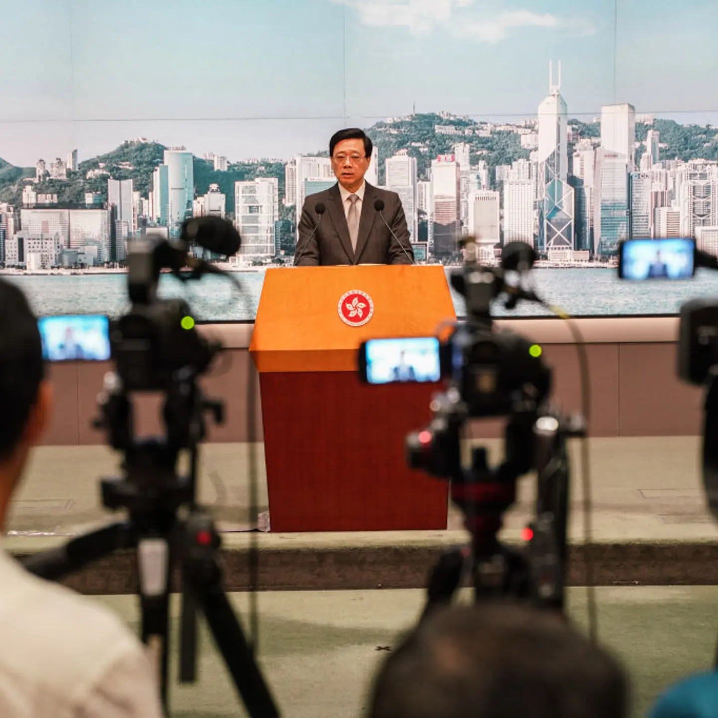 Journalists take videos while John Lee speaks during the
