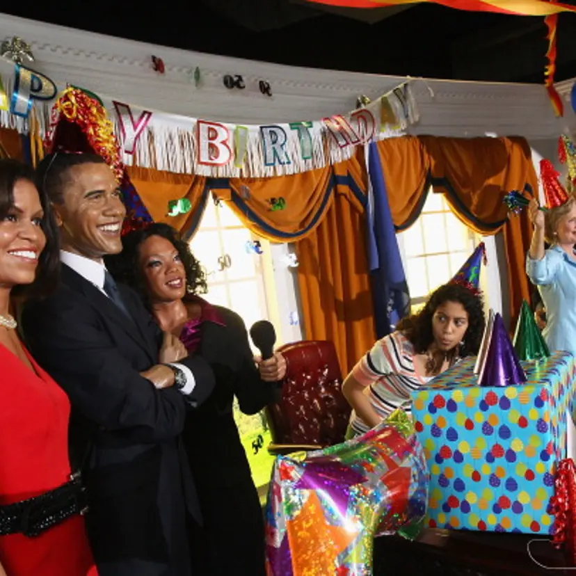 Peninah Pechenik (C), from Buffalo, New York, leans around to take a closer look of wax figures of (L-R) U.S. first lady Michelle Obama, President Barack Obama and Oprah Winfrey while visiting Madame Tussauds Wax Museum on Obama's 50th birthday August 4,