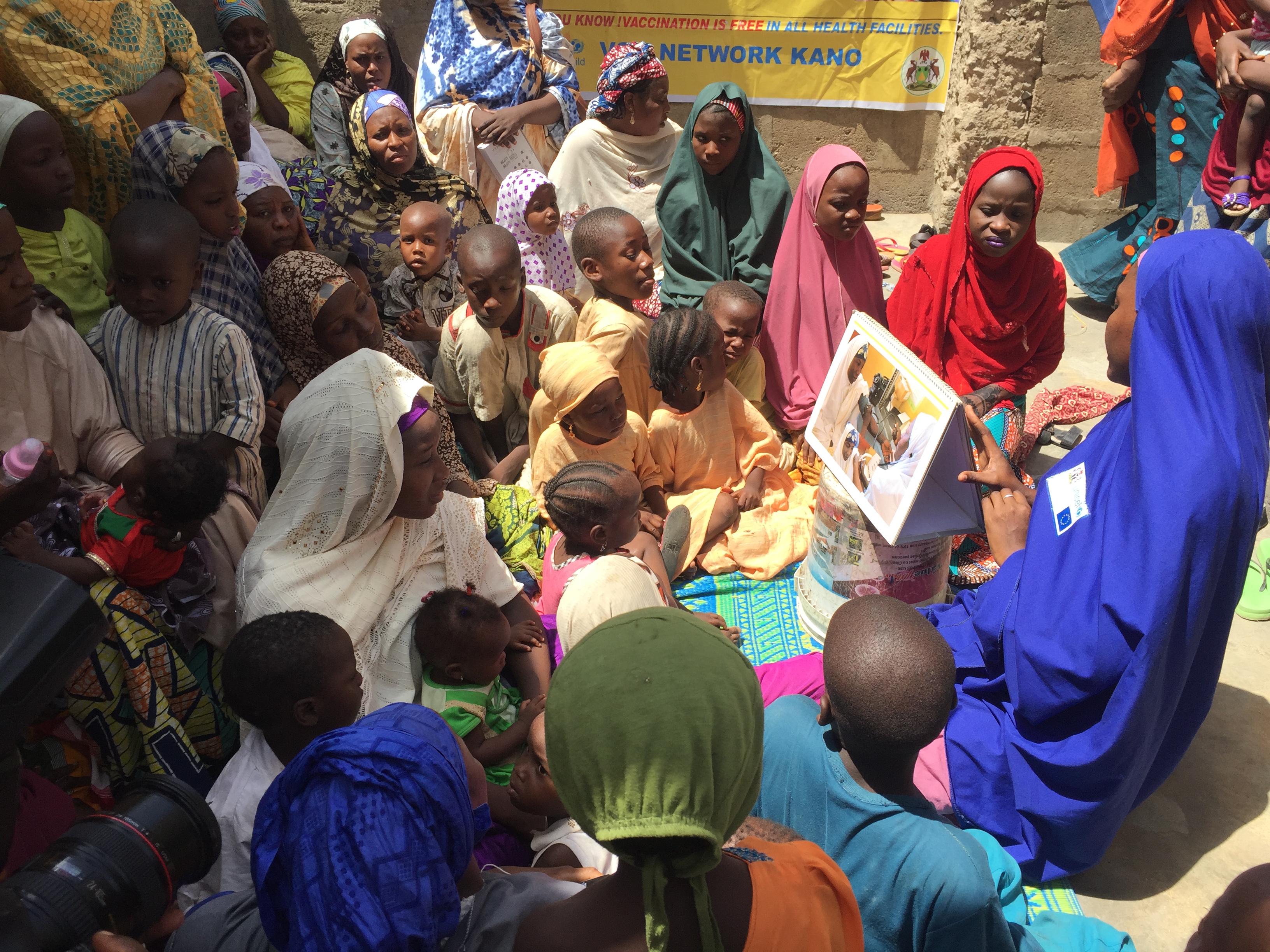 A health care worker from UNICEF and the Bill and Melinda Gates Foundation teaches polio vaccination protocols during a naming ceremony in Kano, Nigeria. 