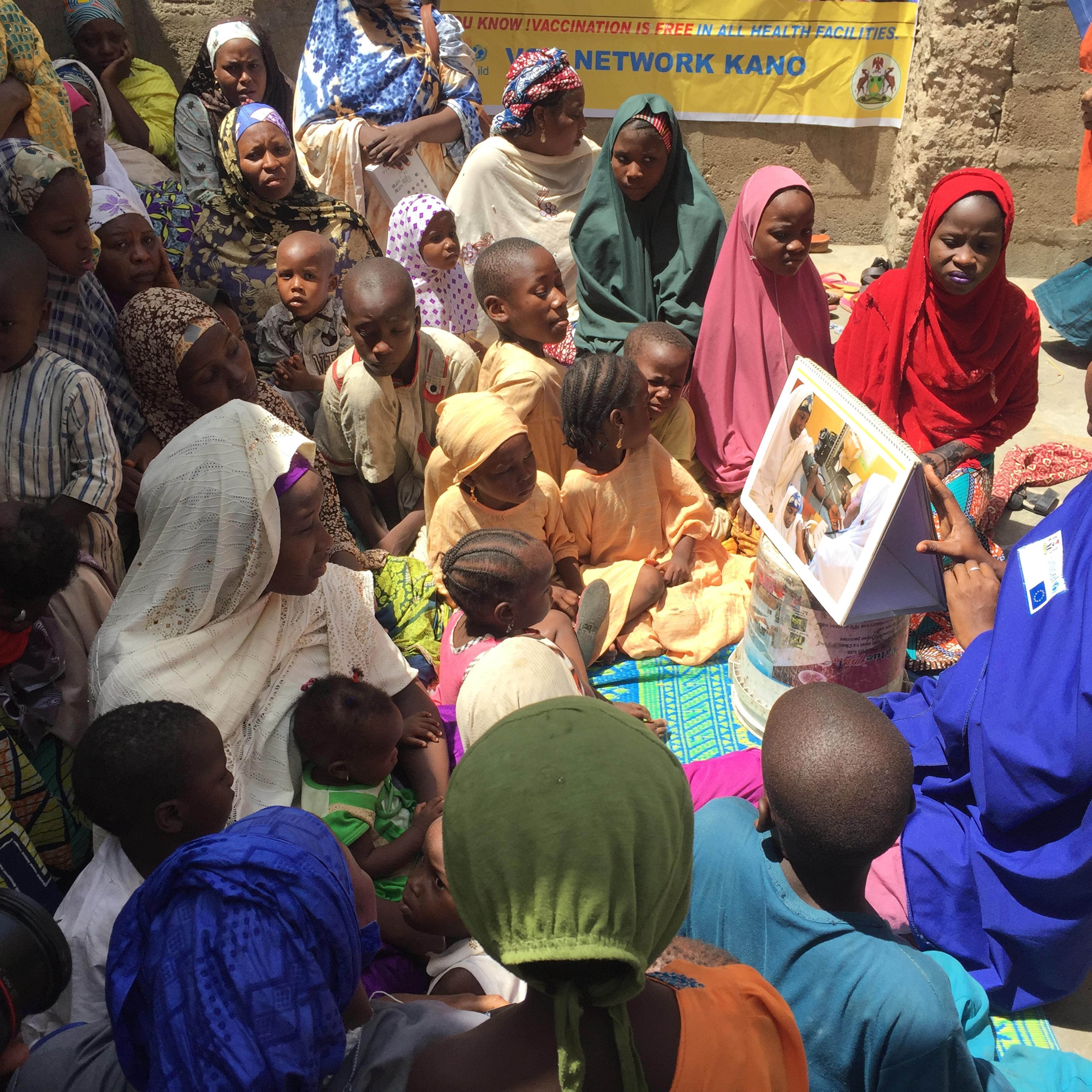 A health care worker from UNICEF and the Bill and Melinda Gates Foundation teaches polio vaccination protocols during a naming ceremony in Kano, Nigeria.