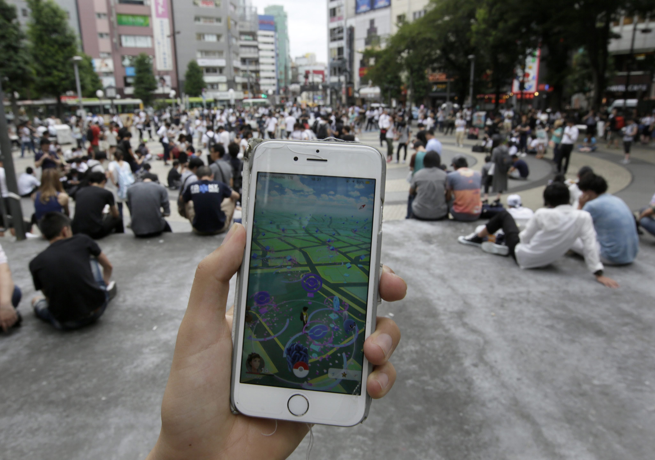 People play Pokemon Go at a park in Tokyo on July 25, 2016.