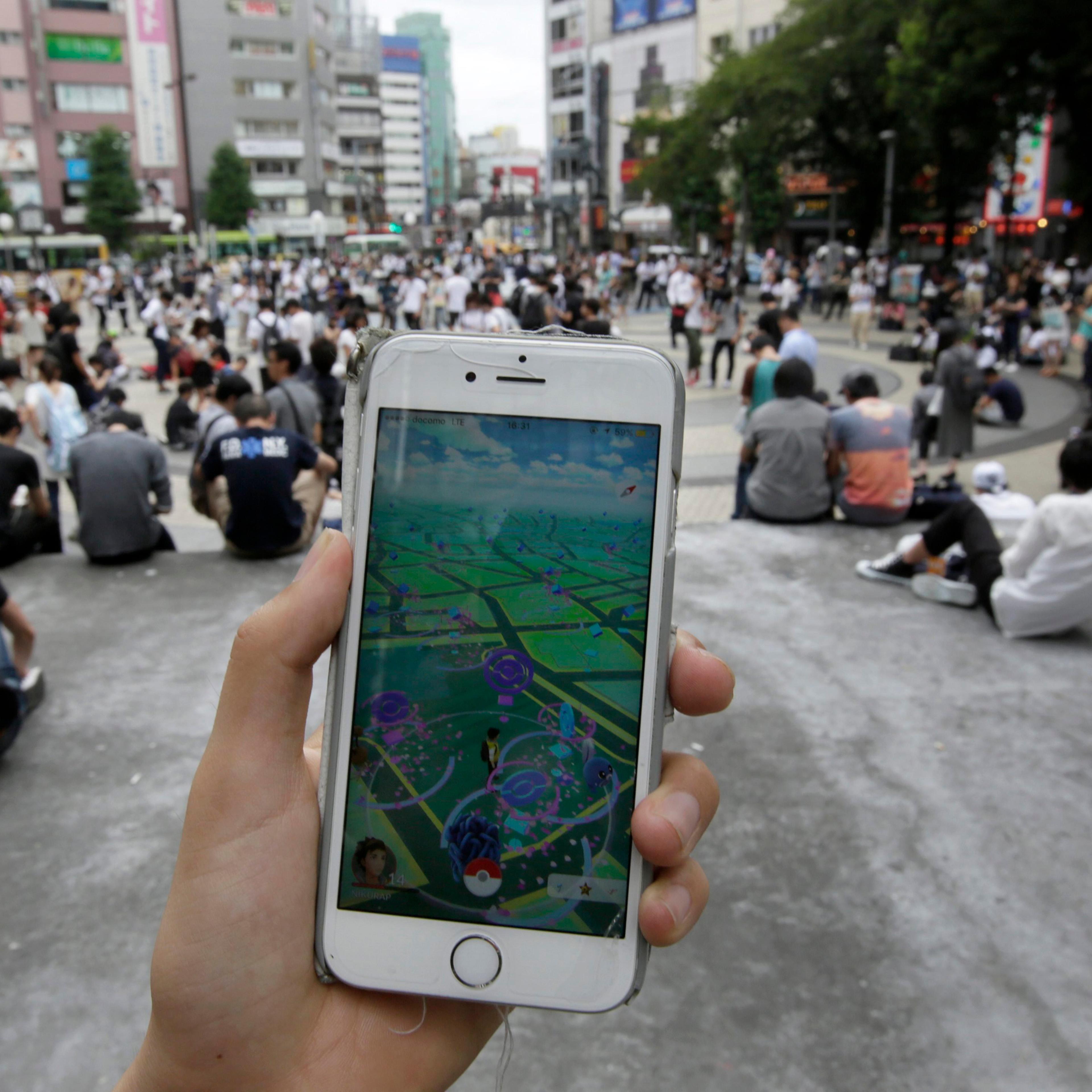 People play Pokemon Go at a park in Tokyo on July 25, 2016.